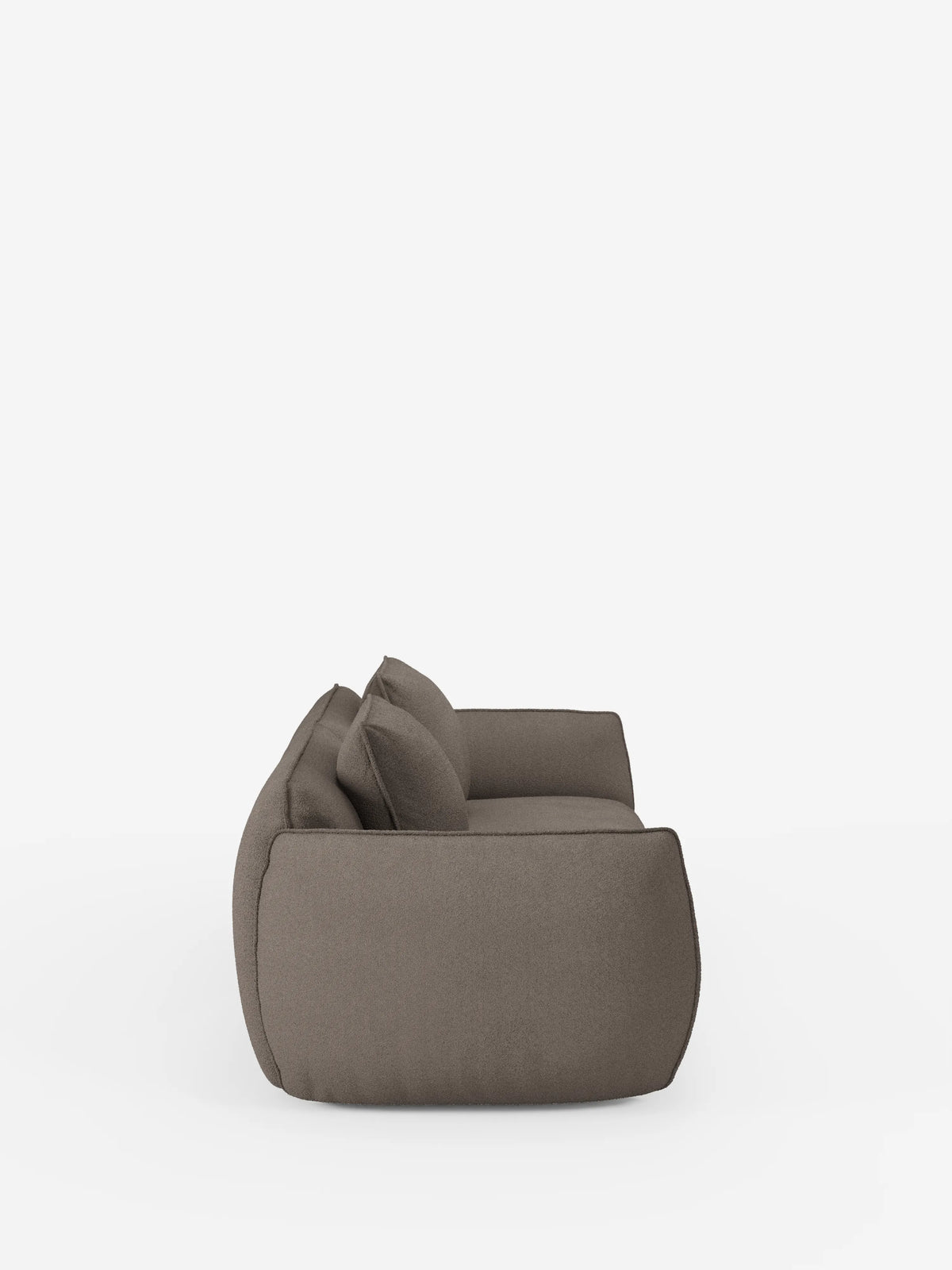 Vista laterale del divano Nimbus a 3 posti, modulare e componibile da 250 cm di Divani.Store, caratterizzato da una linea moderna e slanciata con due cuscini quadrati. Il divano è rivestito in tessuto smacchiabile effetto cotone T33, liscio e di colore grigio-marrone, e presenta un design minimalista e arrotondato con bordi morbidi. È raffigurato su uno sfondo bianco a tinta unita.