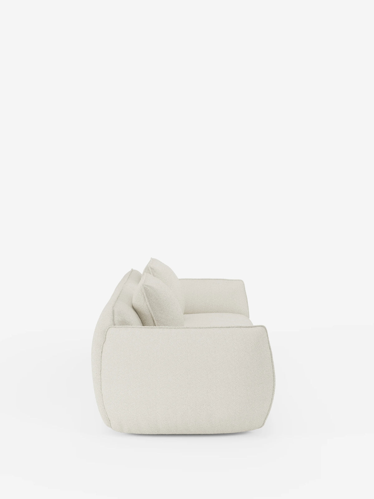 Una vista laterale del divano Nimbus a 3 posti, modulare e componibile, da 250 cm di Divani.Store, presentato in un tessuto beige moderno e minimalista con morbidi cuscini, su uno sfondo bianco a tinta unita. Questo divano presenta un design morbido e arrotondato e un profilo basso, con rivestimento sfoderabile in tessuto effetto cotone antimacchia t33, che conferisce all’arredo un aspetto accogliente e invitante.