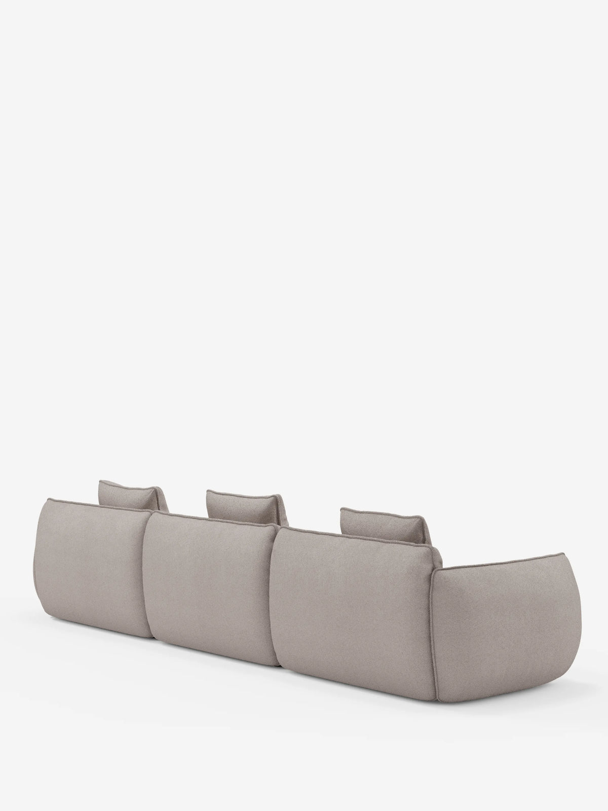 Un divano angolare modulare Nimbus in grigio chiaro, dal design minimalista, di Divani.Store, è raffigurato di spalle su uno sfondo bianco a tinta unita. Il divano presenta tre ampie sedute modulari rivestite in morbido tessuto T33 effetto cotone, resistente alle macchie, con schienali bassi, bordi arrotondati e delicati dettagli di cucitura.