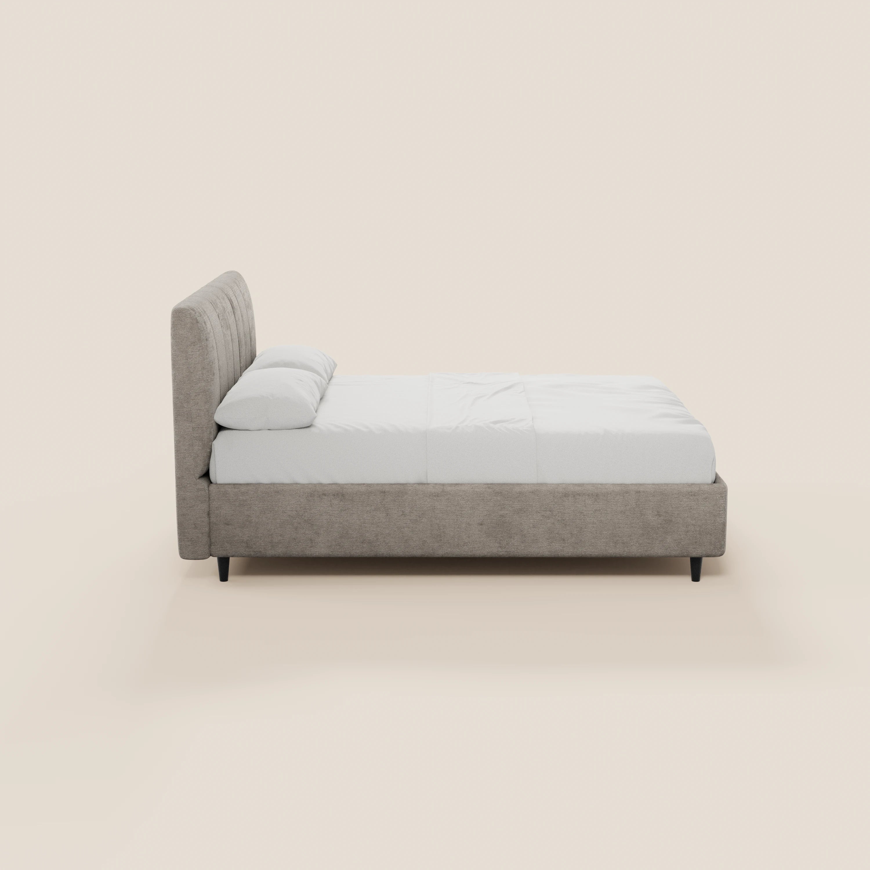 Il letto imbottito ONYX di Letti.store presenta un design minimalista e moderno, con una testiera verticale imbottita di colore grigio chiaro certificata Oeko-Tex®, gambe corte nere, biancheria da letto bianca e due cuscini; nella foto è raffigurato di profilo su uno sfondo beige chiaro.