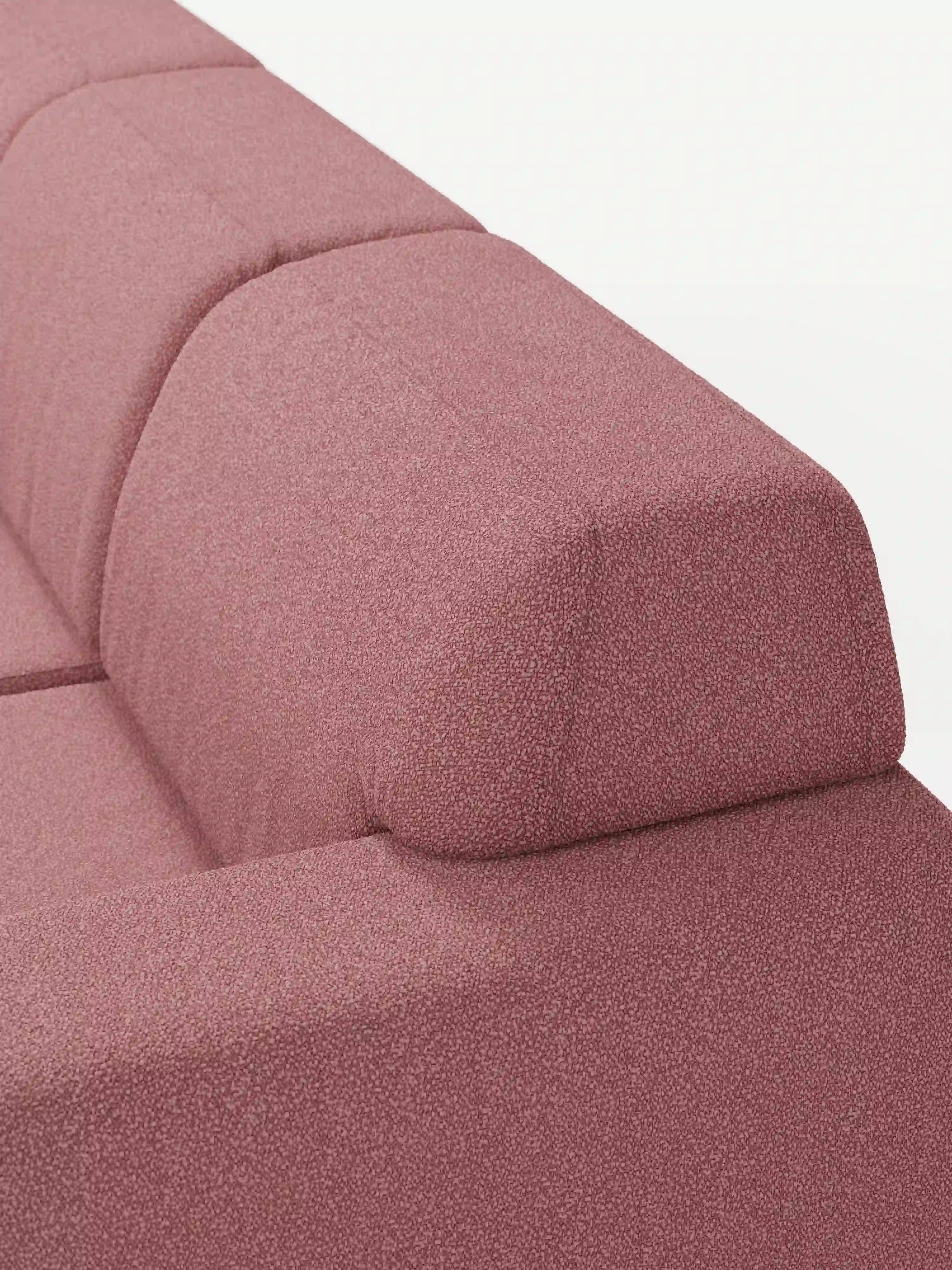 Primo piano del divano angolare Orbit con penisola reversibile e tutte le sedute allungabili di Divani.Store, rivestito in tessuto T33 effetto cotone rosa e resistente alle macchie. L’immagine mette in risalto lo schienale e i braccioli, evidenziandone le linee geometriche pulite e l’imbottitura morbida. Su uno sfondo bianco a tinta unita, spiccano il colore caratteristico e la silhouette moderna del divano.