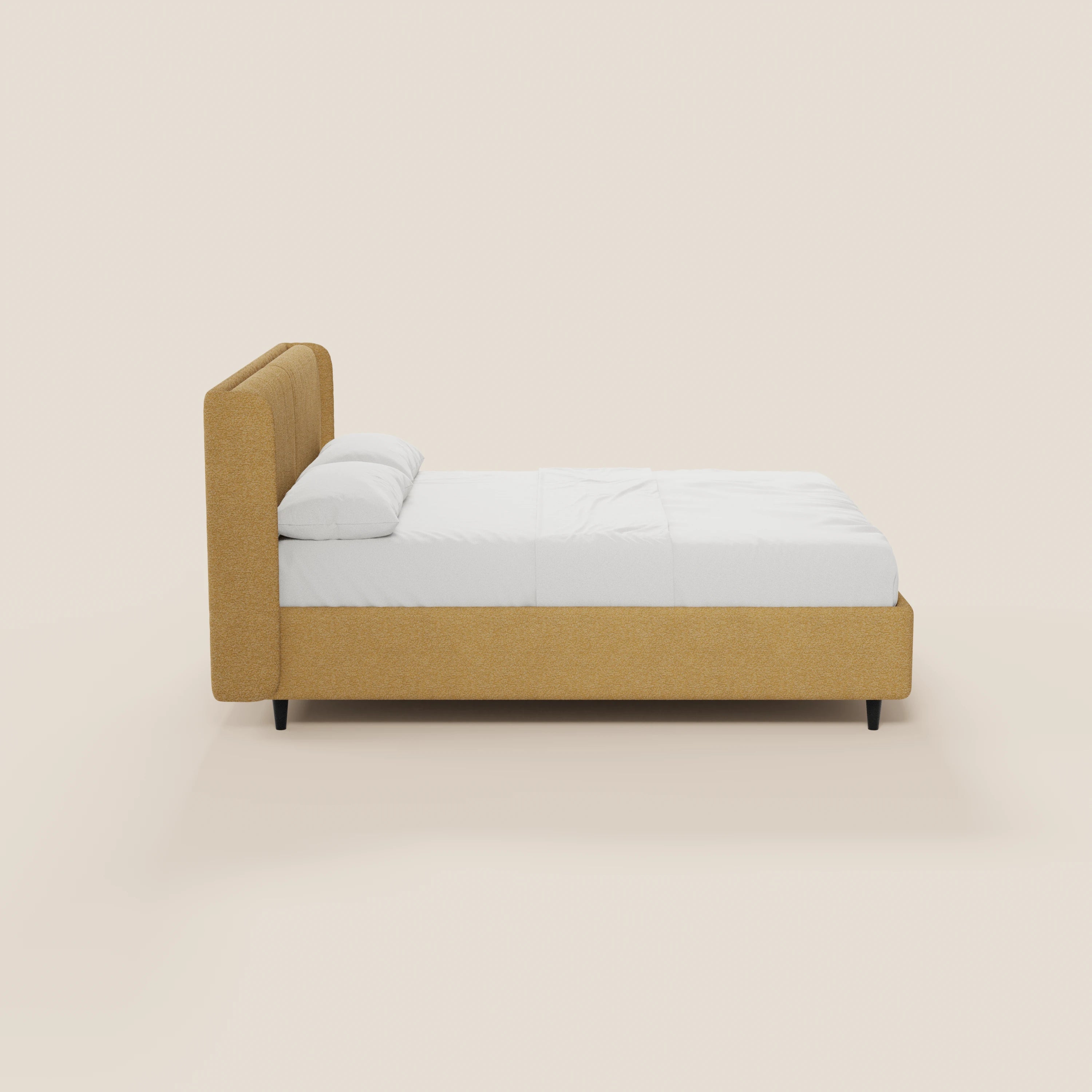 Una vista laterale del letto di design VALKIRIA di Letti.store, caratterizzato da una struttura rivestita in giallo senape certificata Oeko-Tex®, una testiera avvolgente con 2 cuscini imbottiti, gambe corte nere e biancheria da letto bianca, il tutto su uno sfondo beige chiaro.