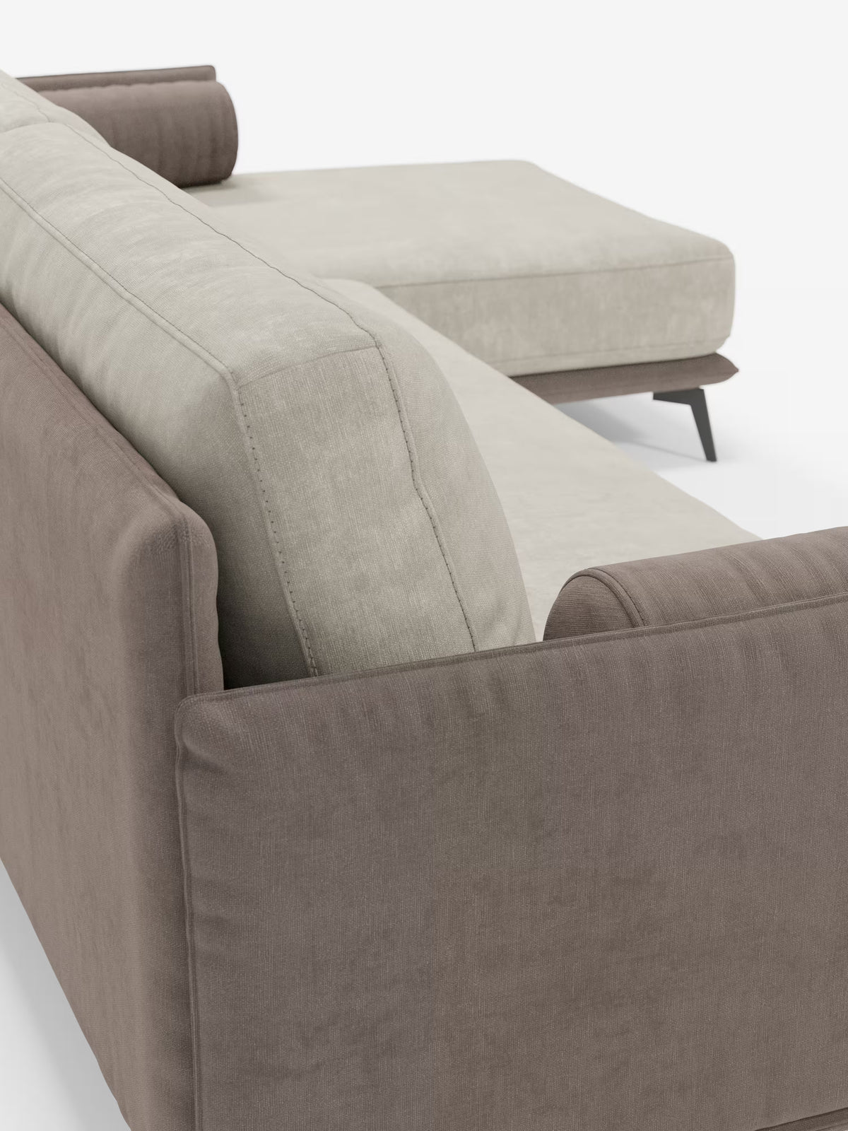 Primo piano del divano angolare bicolore Basalto con penisola e base in metallo di Divani.Store, caratterizzato da fianchi e schienale color taupe-marrone e cuscini di seduta e schienale beige chiaro, rivestiti in tessuto smacchiabile T31. Gli schienali sono imbottiti in piuma per un maggiore comfort, mentre i braccioli e il cuscino cilindrico aggiungono un tocco di raffinatezza. Caratterizzato da linee pulite e da un design minimalista, questo divano poggia su gambe angolari in metallo scuro su uno sfondo