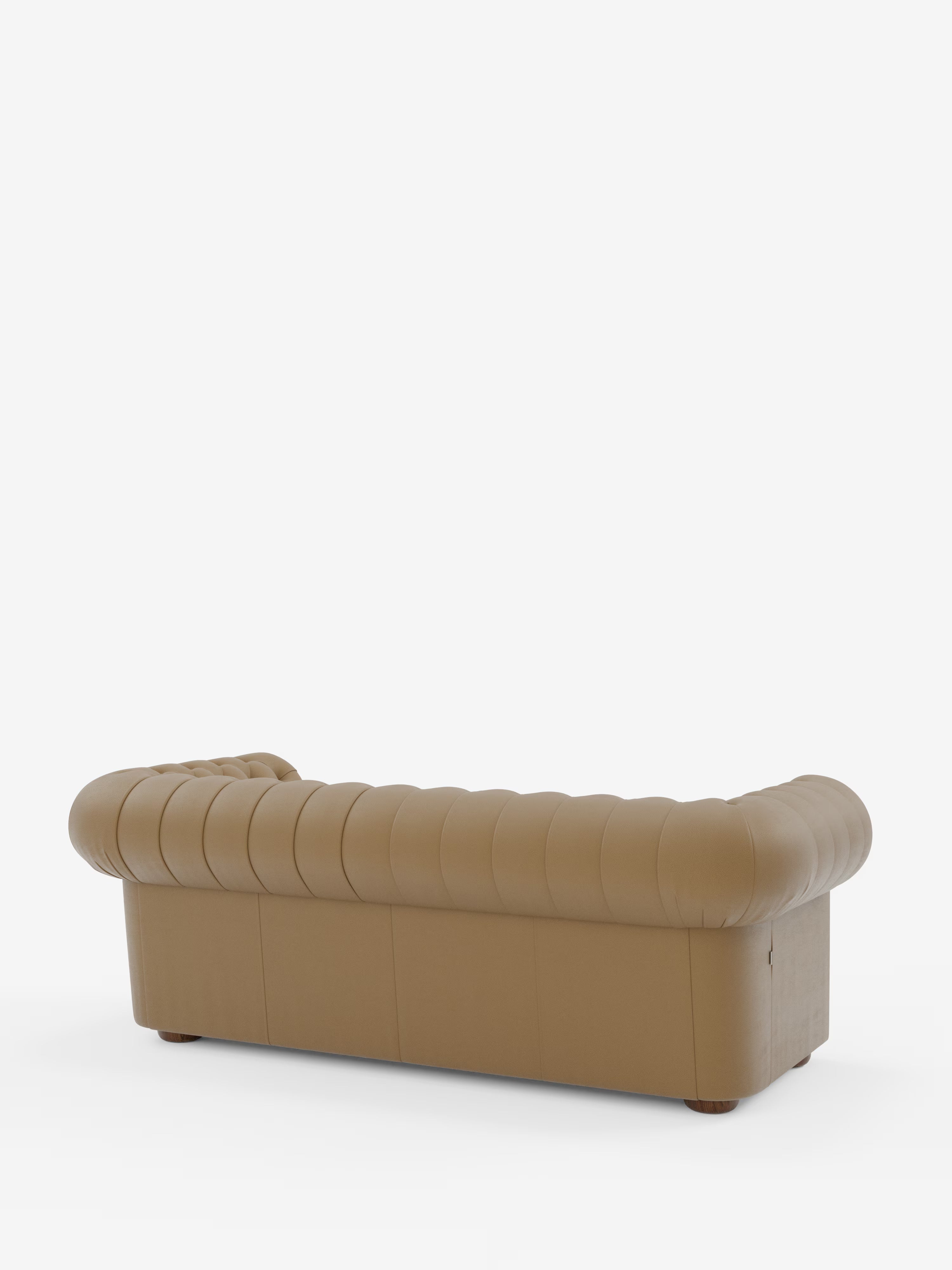 Un Chester color cuoio – Divano Chesterfield in vera pelle spessorata a 2 e 3 posti di Divani.Store, visto da dietro con rivestimento profondamente trapuntato, braccioli ricurvi che si allineano all’altezza dello schienale e gambe corte in legno su uno sfondo bianco a tinta unita: un divano elegante e artigianale Made in Italy.