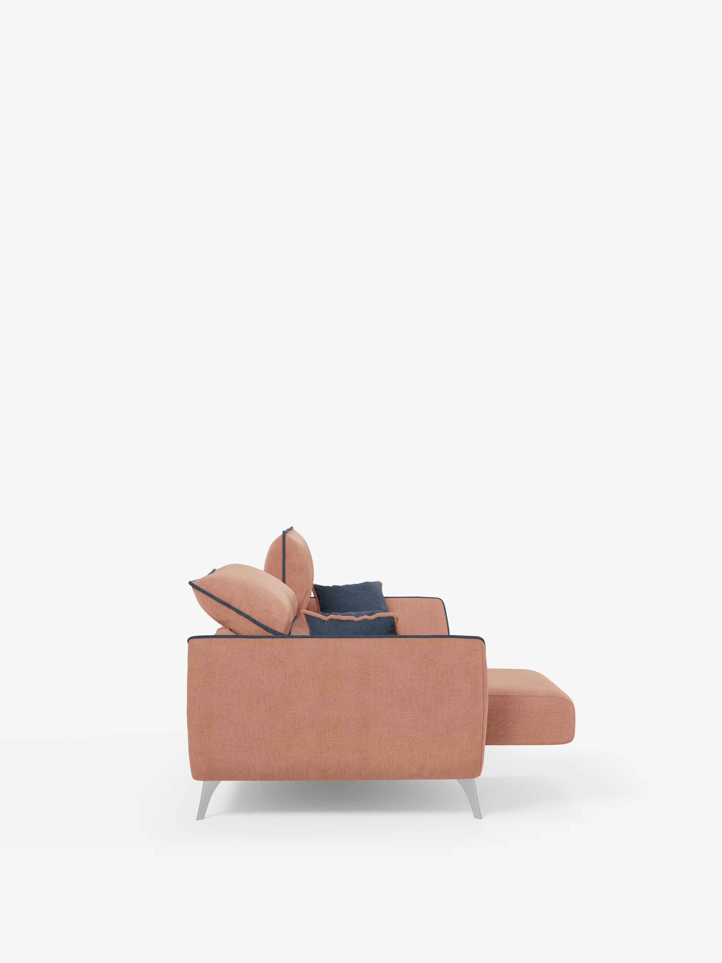 Vista laterale del divano Michelangelo a 2 e 3 posti con sedute allungabili e poggiatesta reclinabili di Divani.Store, realizzato in tessuto bicolore smacchiabile T23. Il design moderno è caratterizzato da gambe in metallo angolate e due ampi cuscini dello schienale, completati da due cuscini decorativi blu navy appoggiati allo schienale per sottolinearne lo stile contemporaneo. Su uno sfondo bianco e minimalista, il divano spicca come elemento centrale dell’ambiente.