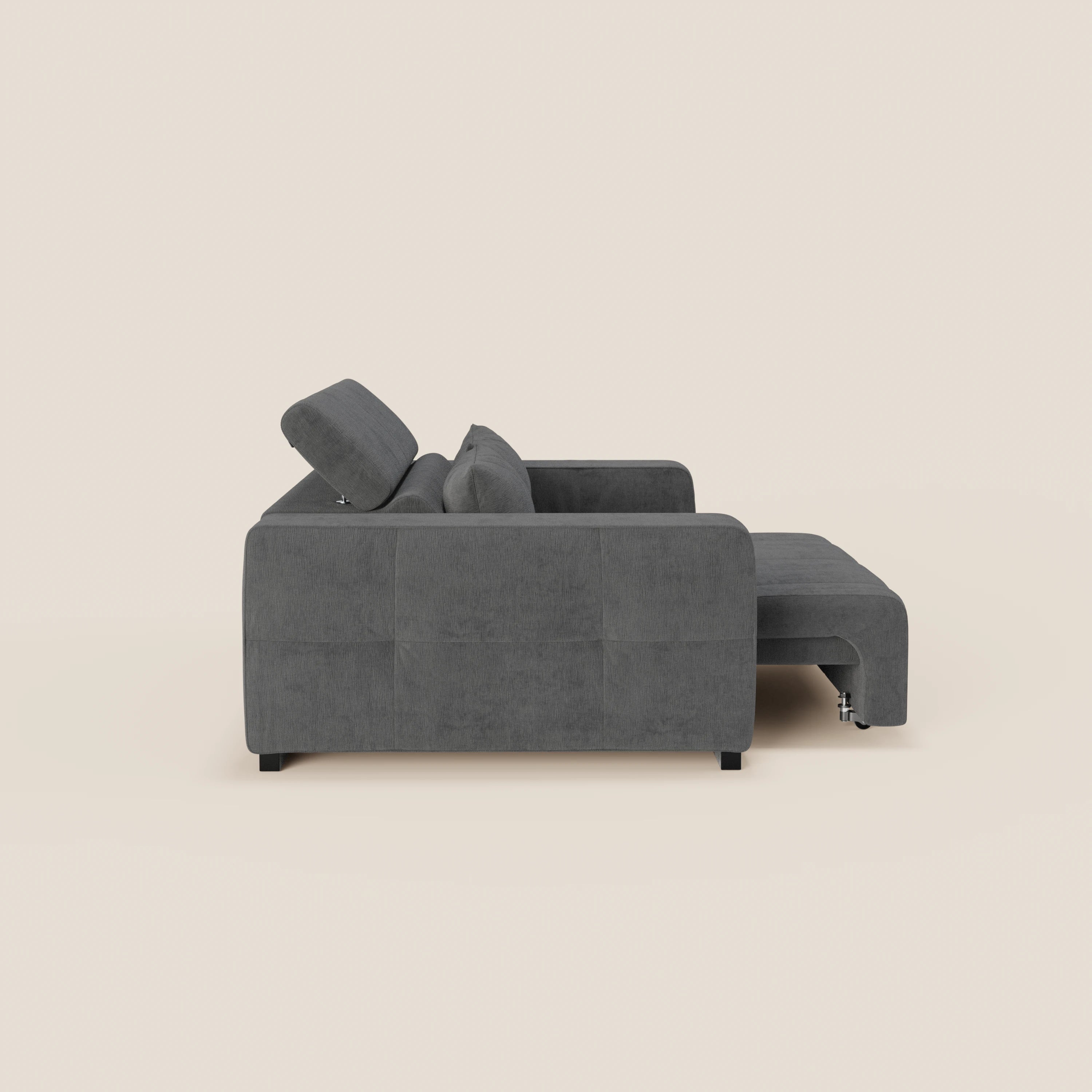 Vista laterale del Monarch Divano con Relax Elettrico di Divani.Store, un moderno divano grigio scuro con chaise longue a destra, linee pulite, braccioli squadrati, poggiatesta regolabile e tessuto T31 antimacchia su uno sfondo beige chiaro.