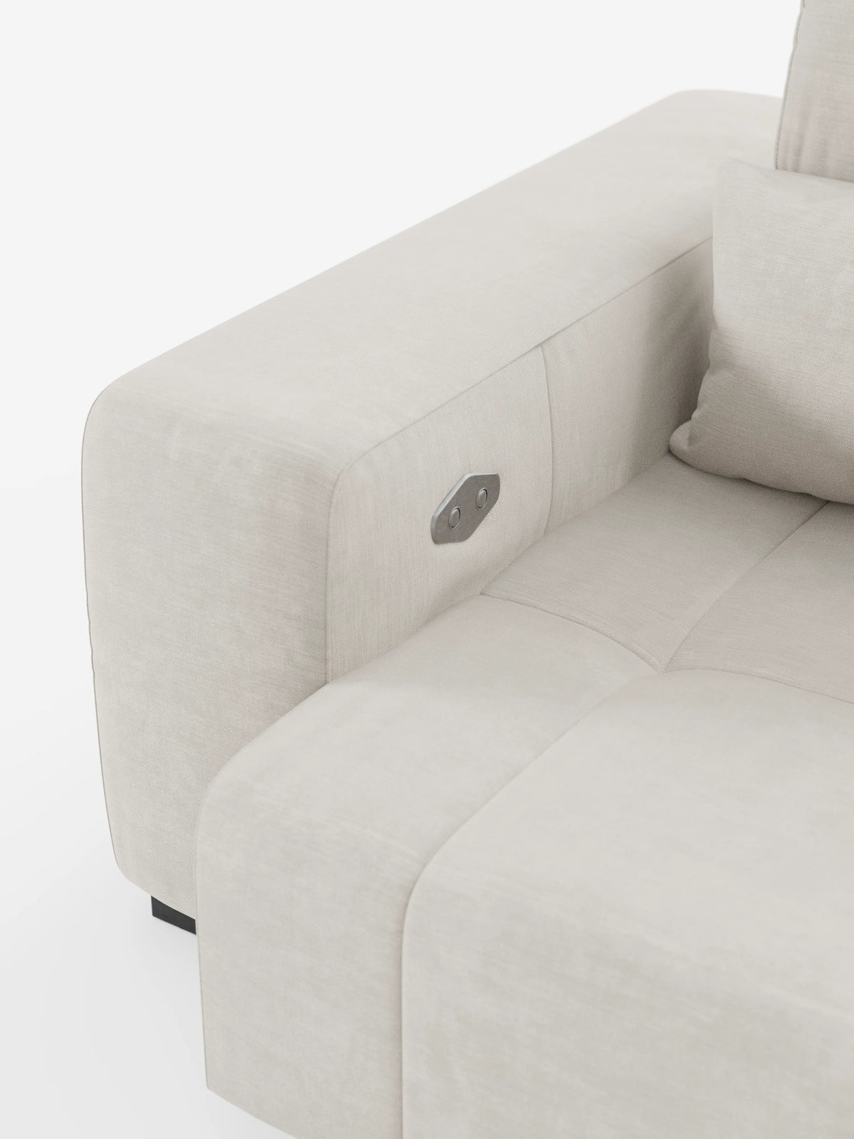 Un primo piano del divano Monarch con relax elettrico per l’allungamento delle sedute e poggiatesta reclinabile in morbido tessuto smacchiabile T31 di Divani.Store mette in risalto i braccioli in tessuto beige chiaro, dotati di un pannello di comando in metallo integrato. Il cuscino della seduta e il cuscino coordinato mettono in risalto le cuciture eleganti e pulite e un design minimalista su uno sfondo bianco, catturando perfettamente l’essenza di un divano contemporaneo.