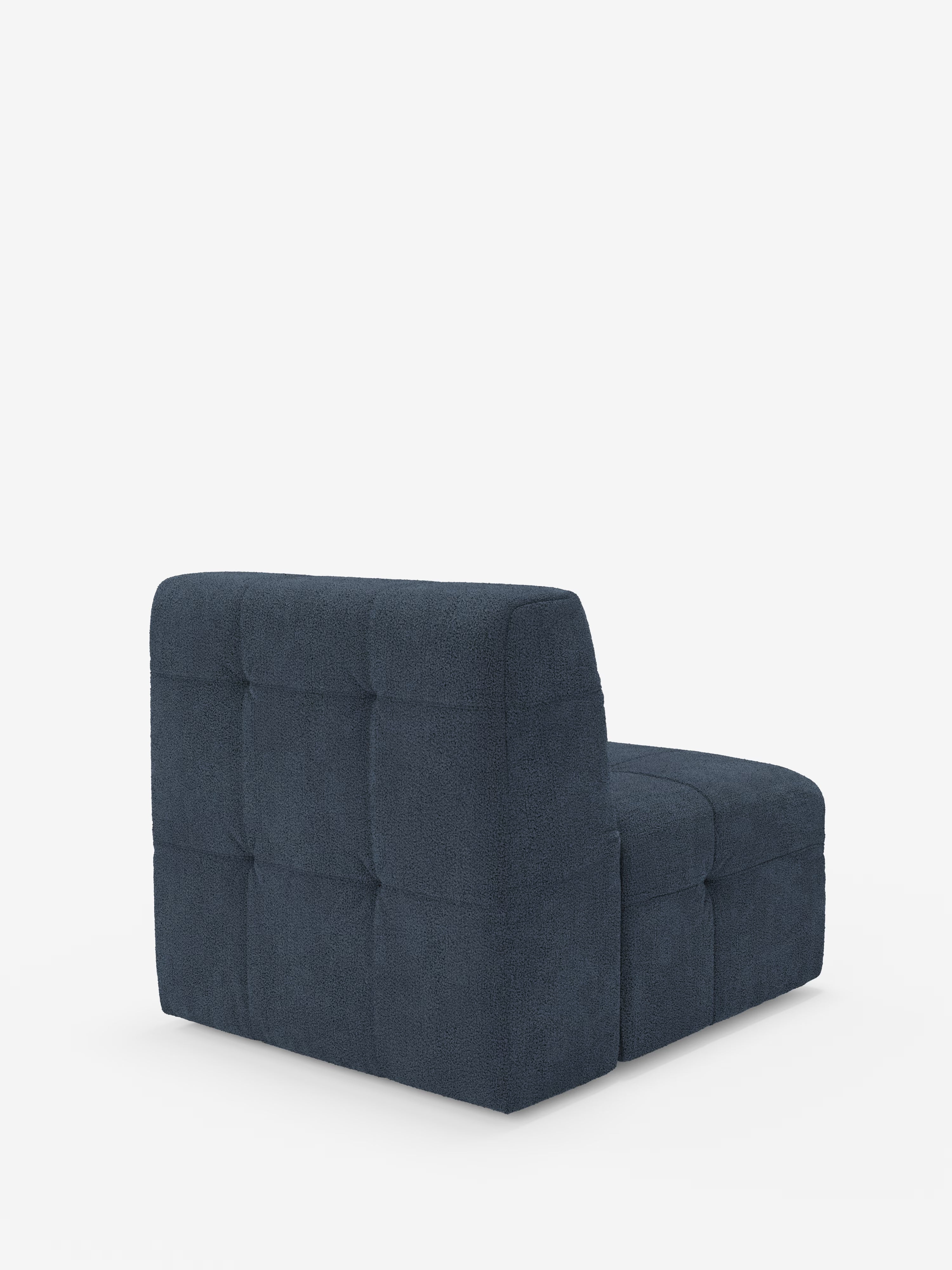 Una poltrona modulare Mosaic blu scuro (77 cm) in tessuto bouclé di Divani.Store, caratterizzata da un design capitonné e trapuntato con rivestimento testurizzato T21 antimacchia. Questo divano modulare senza braccioli presenta uno schienale basso e una seduta composta da segmenti quadrati imbottiti. È posizionato su uno sfondo bianco a tinta unita e leggermente inclinato verso destra.
