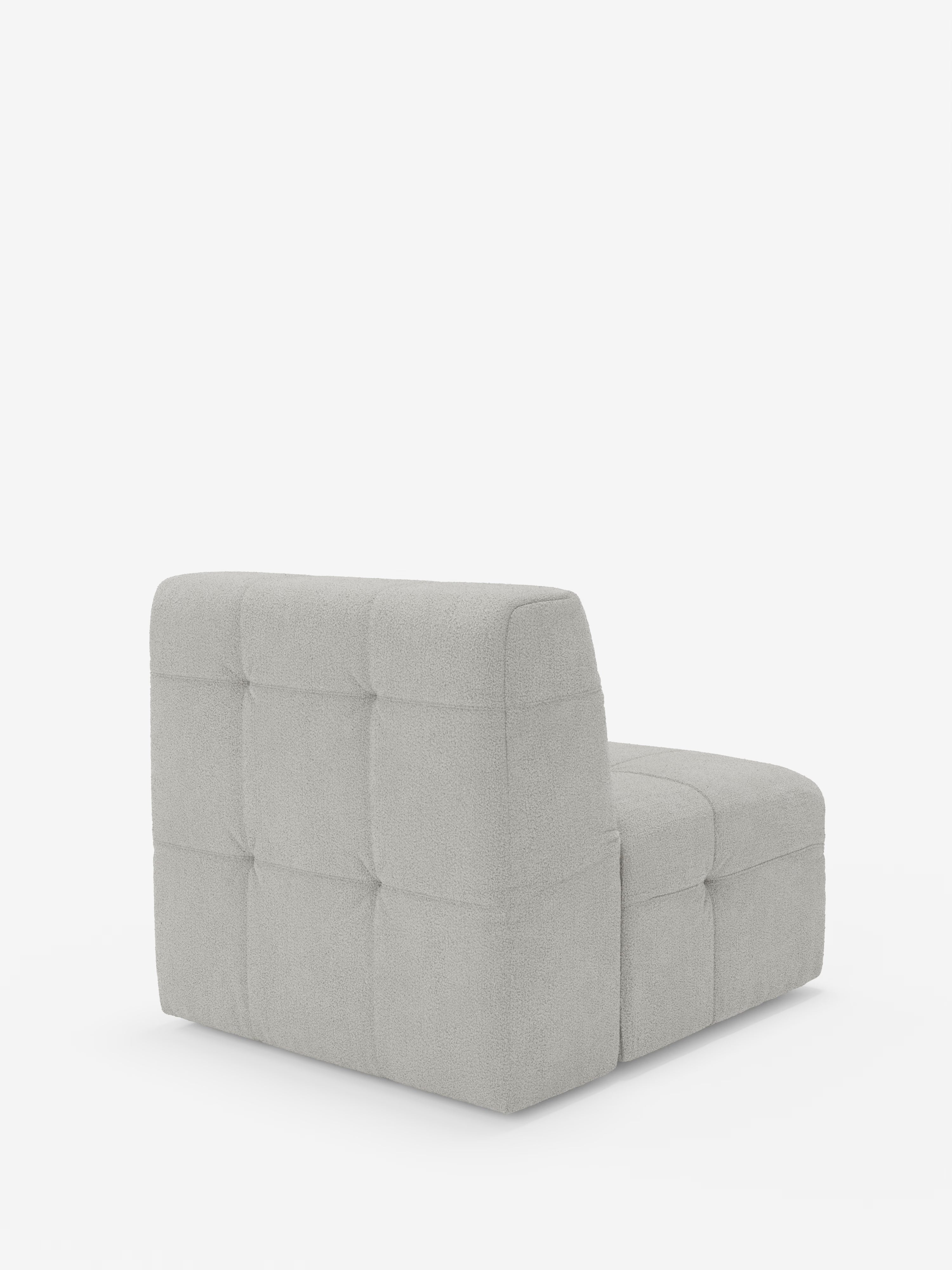 La poltrona modulo Mosaic da 77 cm in bouclé di Divani.Store è un elemento divano moderno, senza braccioli, caratterizzato da uno schienale basso e una seduta profonda. Rivestita in morbido tessuto bouclé T21 resistente alle macchie, la sua superficie presenta una griglia di ampi pannelli capitonné quadrati che richiamano il design delle poltrone di alta gamma. Sullo sfondo bianco a tinta unita, le linee pulite sottolineano lo stile contemporaneo di questo complemento d’arredo.