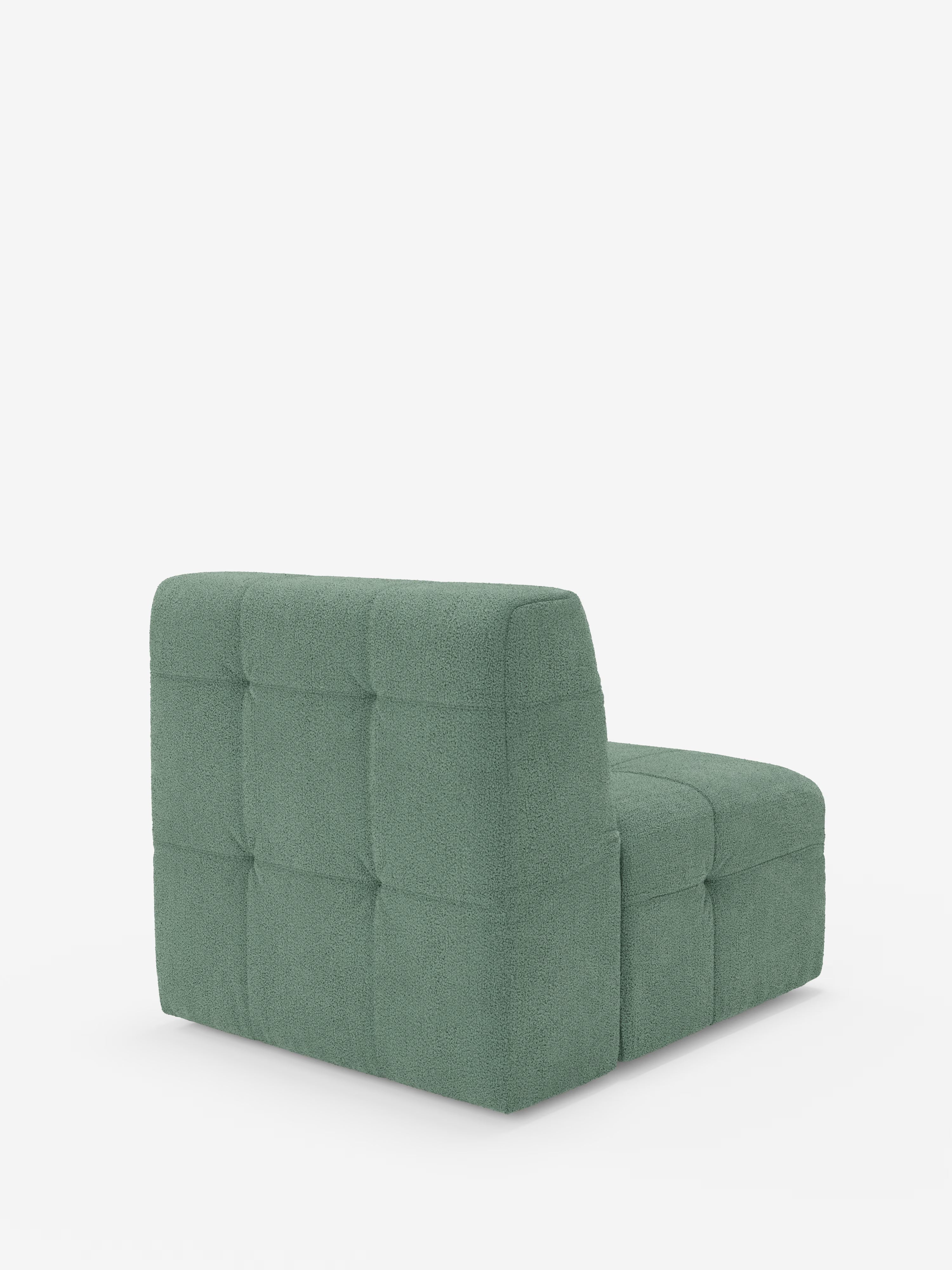 Una poltrona di design contemporaneo senza braccioli — la Mosaic modulo poltrona 77 cm in bouclé di Divani.Store — presenta un morbido rivestimento verde trapuntato (capitonné) realizzato in tessuto T21 resistente alle macchie. Il design raffinato di questa poltrona mette in risalto lo schienale basso e squadrato ed è presentato con eleganza su uno sfondo bianco a tinta unita, senza altri oggetti visibili.