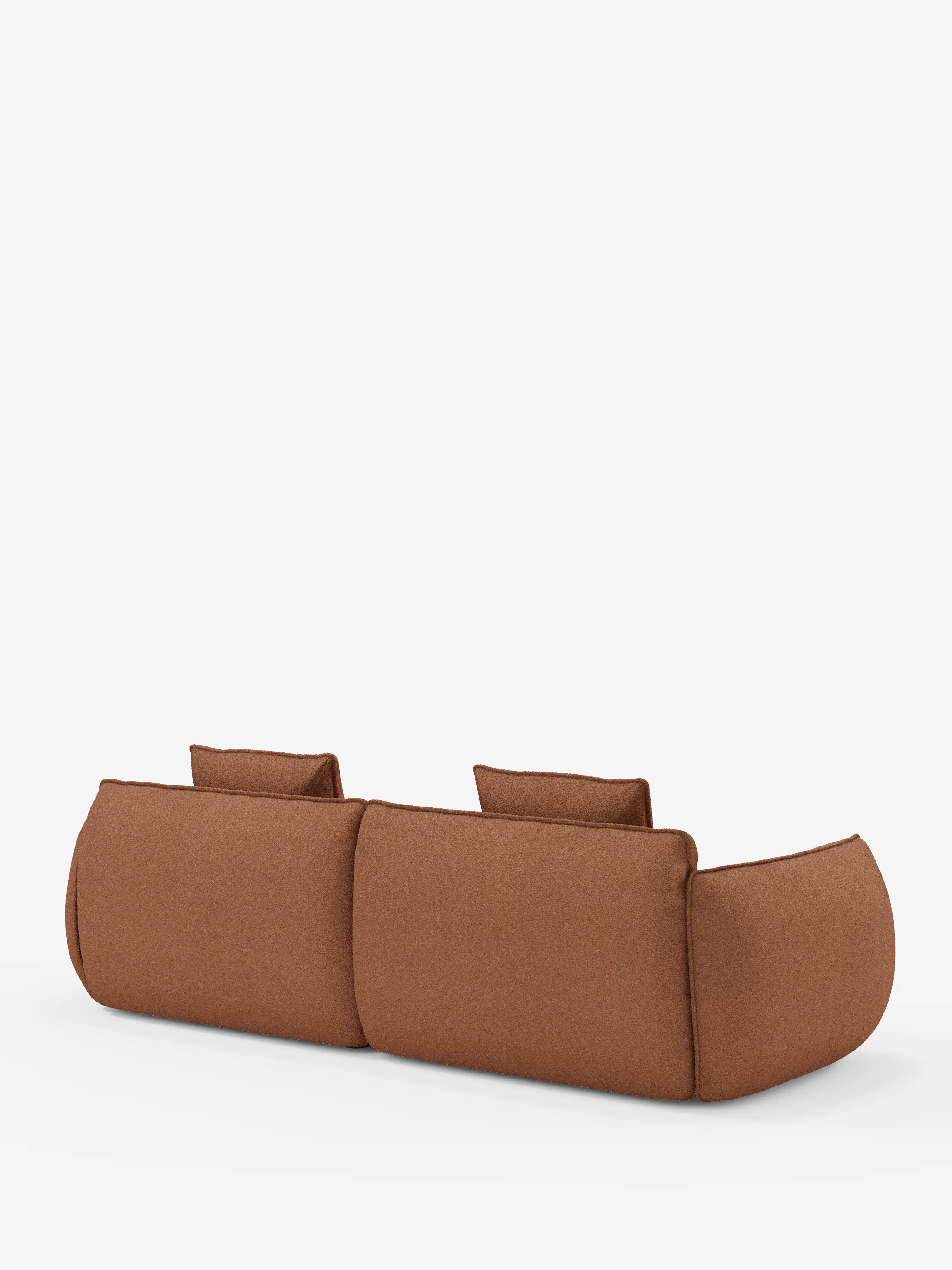 Un divano a 3 posti modulare e componibile Divani.Store Nimbus (250 cm) in stile contemporaneo e minimalista, color marrone, con bordi arrotondati, ripreso dal retro su uno sfondo bianco a tinta unita. Questo divano componibile è dotato di due cuscini dello schienale e presenta un profilo basso e morbido, con un rivestimento in tessuto soffice e sfoderabile in una finitura effetto cotone facile da pulire (tessuto smacchiabile effetto cotone t33), che offre sia uno stile moderno che un elevato comfort.