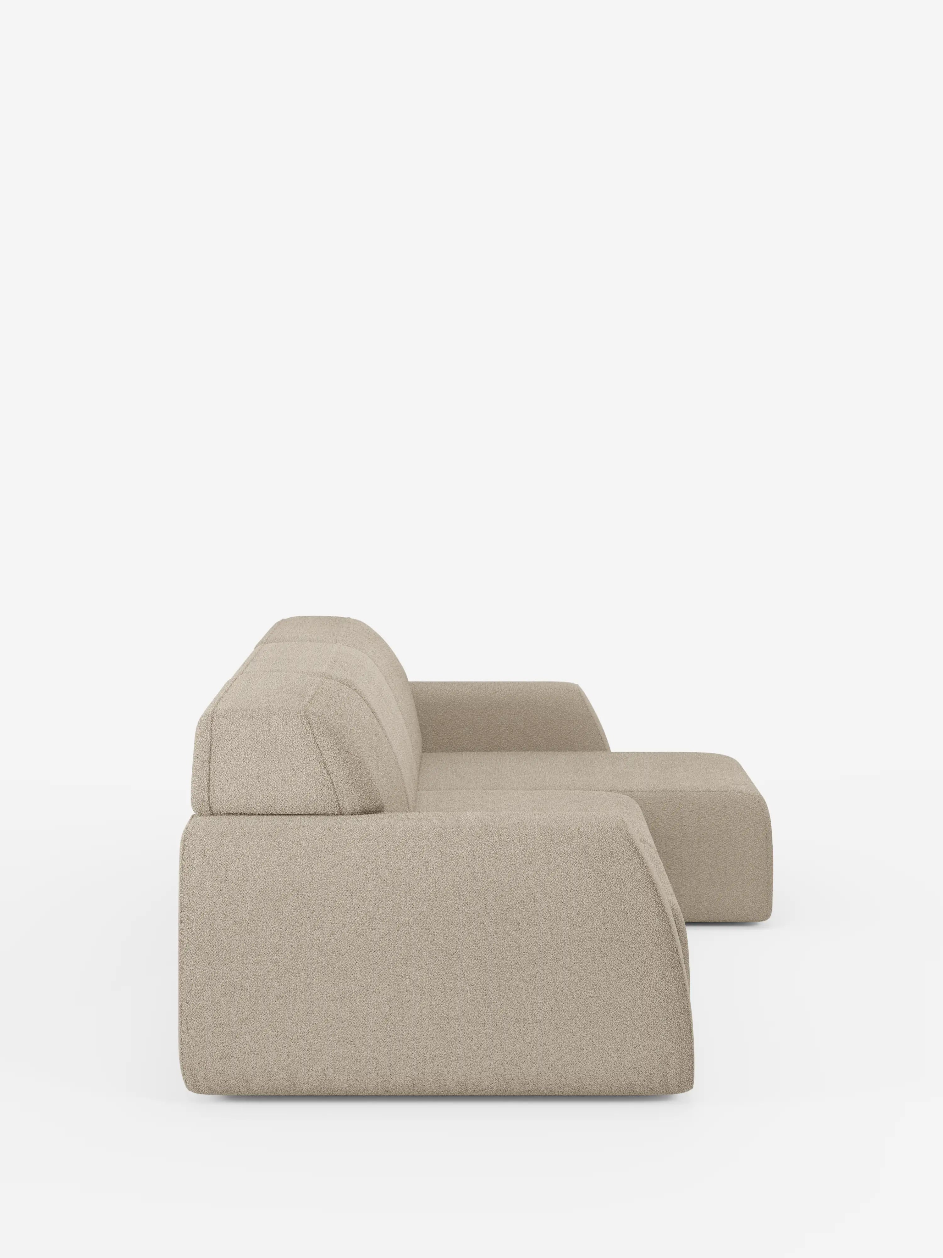 Il divano angolare Orbit con penisola reversibile e tutte le sedute allungabili in tessuto smacchiabile effetto cotone T33 di Divani.Store è raffigurato di profilo su uno sfondo bianco. Questo moderno divano componibile beige presenta uno schienale basso, ampi cuscini di seduta e linee morbide e pulite, senza gambe a vista né dettagli decorativi.