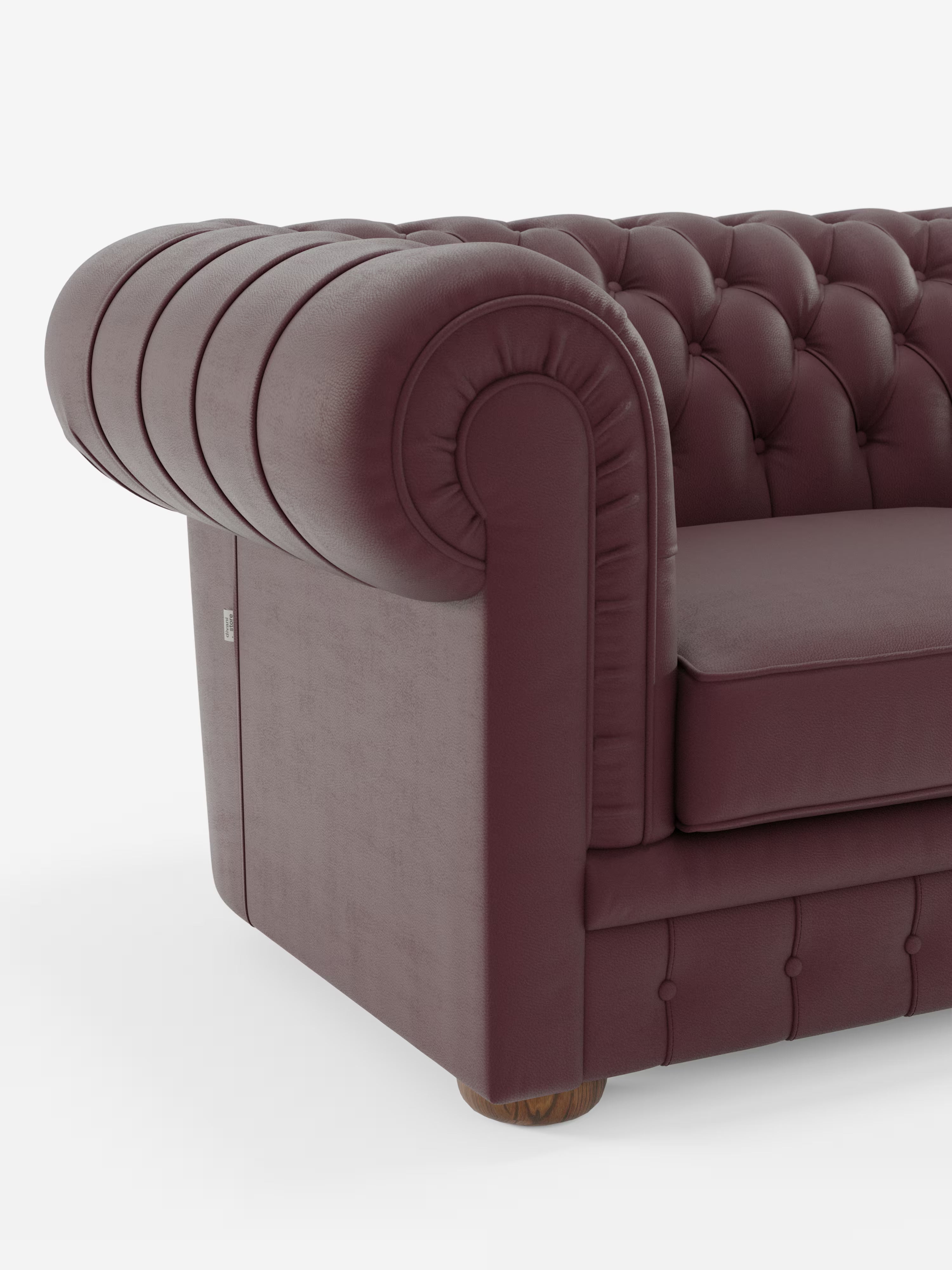 Primo piano del lato sinistro del divano Chester – Divano Chesterfield in vera pelle spessorata a 2 e 3 posti di Divani.Store, che ne mette in risalto il rivestimento in pelle color bordeaux, il design dei braccioli arrotondati, la profonda trapuntatura a bottoni e la gamba arrotondata in legno su uno sfondo bianco.