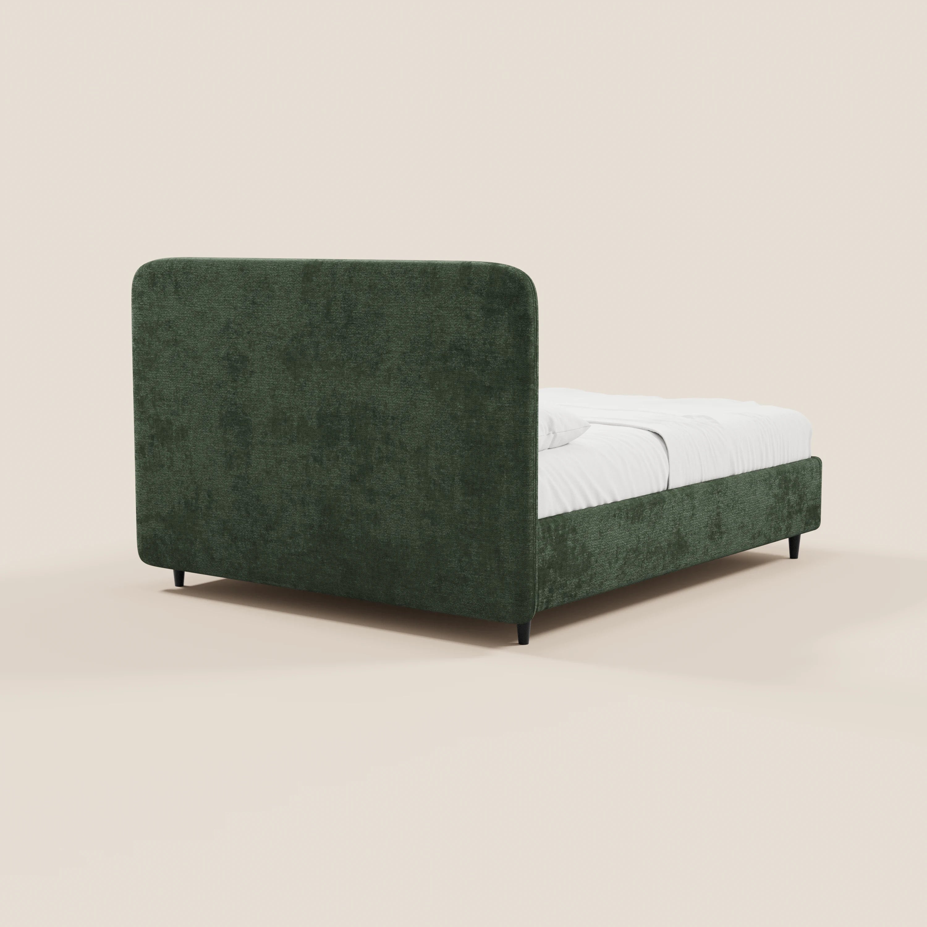 Il letto imbottito KAELOS minimal di Letti.store presenta una struttura rivestita in ciniglia verde scuro, una testiera arrotondata, gambe alte e un vano contenitore. Sullo sfondo beige con biancheria da letto bianca, viene ripreso da un angolo posteriore per un look moderno.