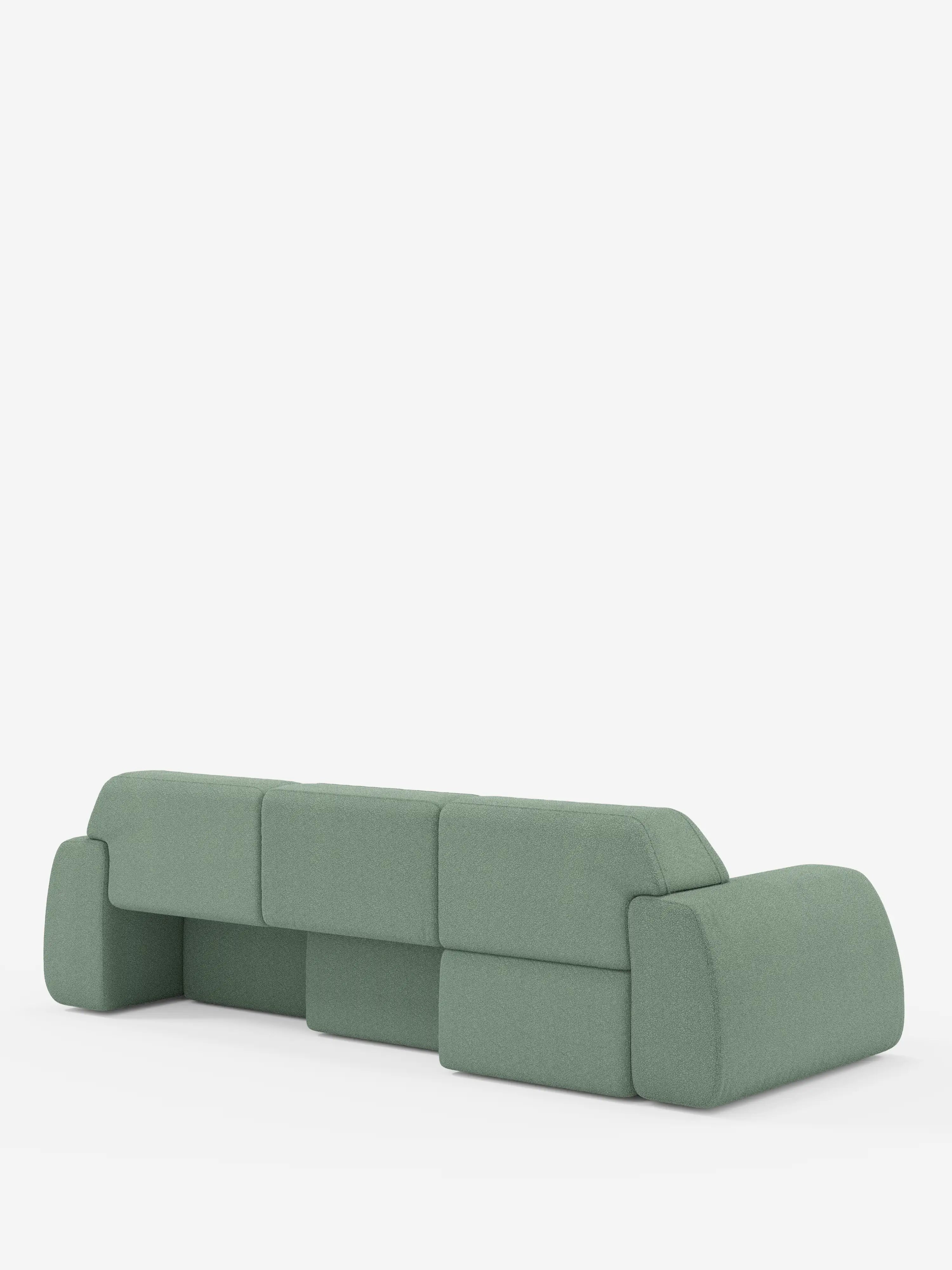 Un divano Orbit moderno e minimalista, di colore verde, con 3 sedute scorrevoli e allungabili in tessuto effetto cotone antimacchia T33 di Divani.Store, caratterizzato da cuscini spessi e arrotondati e schienali bassi, è ripreso di retro su uno sfondo bianco a tinta unita. Il divano non presenta gambe a vista e sfoggia un design modulare e geometrico con rivestimenti completamente sfoderabili per una facile manutenzione.