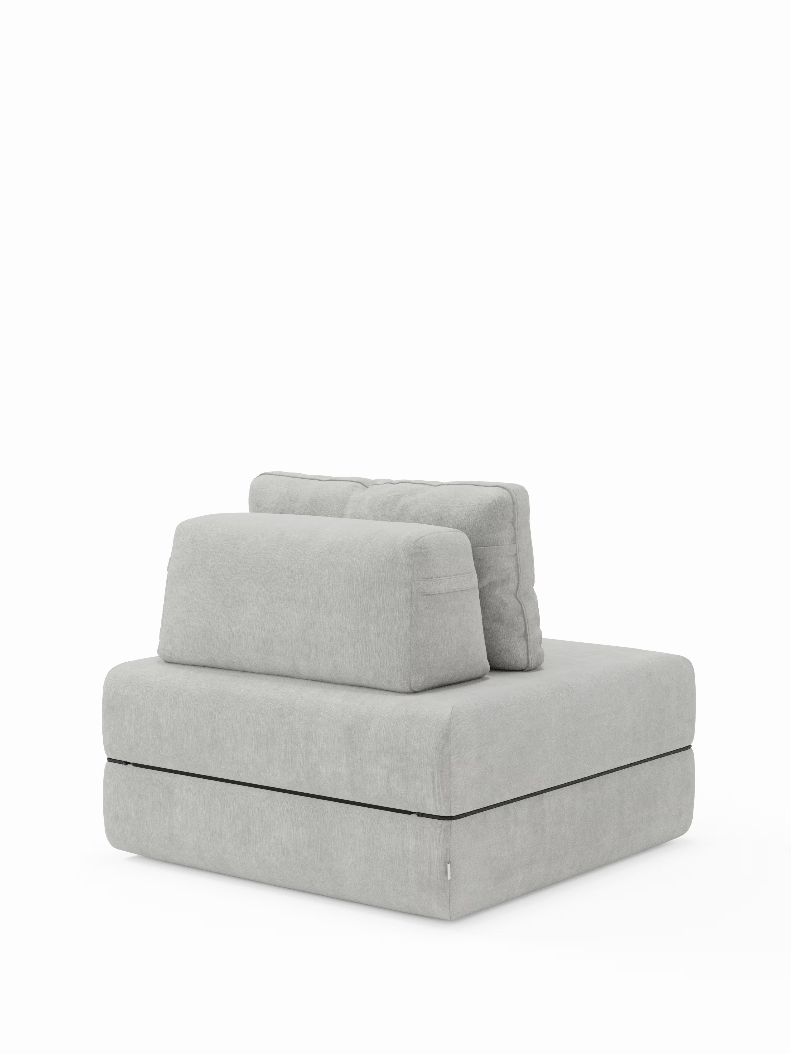 Vi presentiamo la poltrona letto Rift con materasso alto 22 cm e memory foam di Divani.Store: una poltrona contemporanea senza braccioli, di colore grigio chiaro, caratterizzata da due cuscini rettangolari per lo schienale e da una base quadrata dalle dimensioni generose con imbottitura spessa. Il suo rivestimento T31, facile da pulire, è morbido al tatto, mentre il design minimalista — con lo schienale mobile — richiama l’estetica delle moderne poltrone letto. Presentata su uno sfondo bianco a tinta unita.