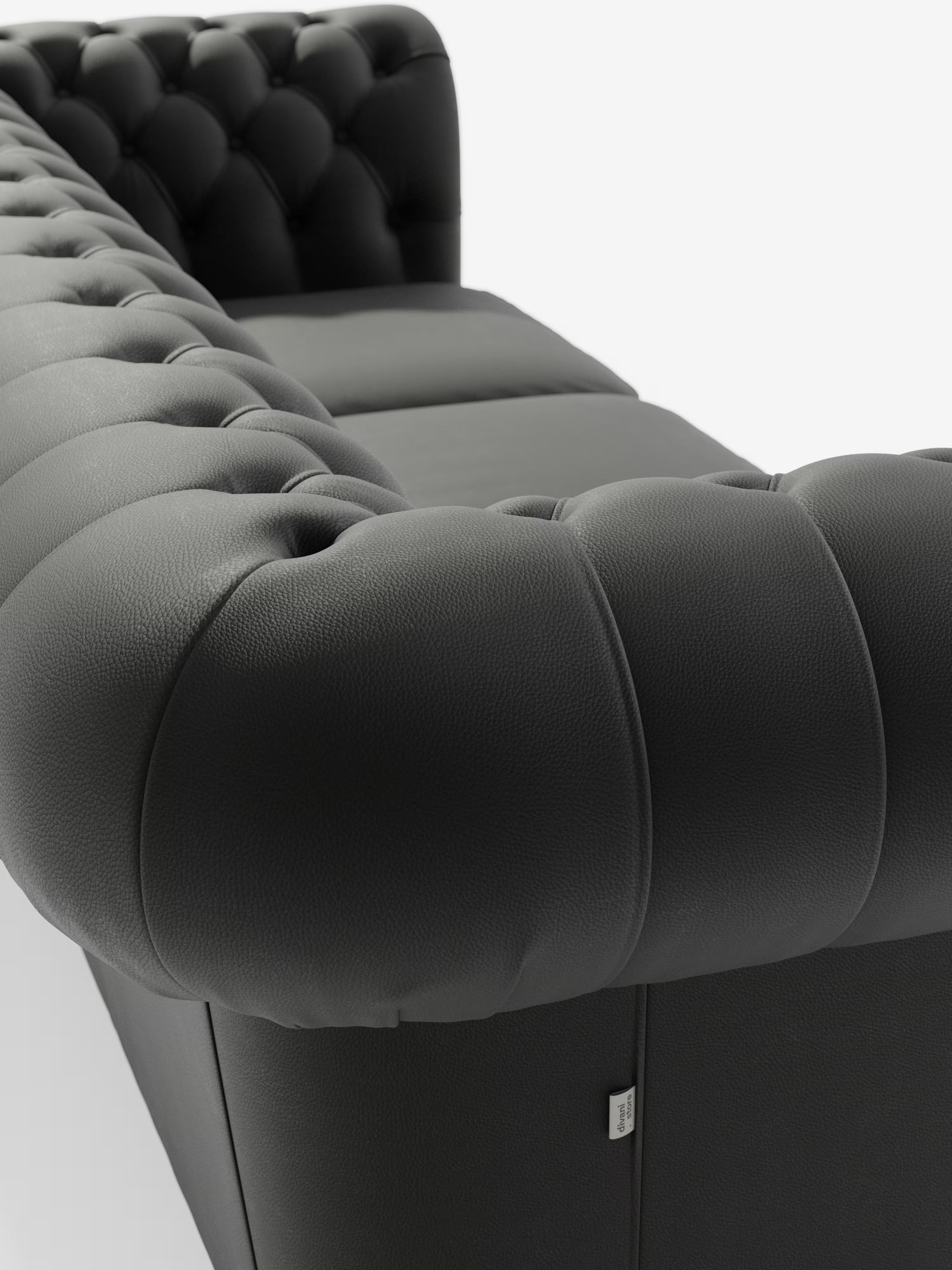 Ecco una versione rielaborata della frase utilizzando i dati del tuo prodotto: Primo piano del Chester 4 Posti 3 sedute in Vera Pelle – Chesterfield Capitonné Artigianale di Divani.Store, realizzato in moderna pelle vera grigio scuro. L’immagine mette in risalto i braccioli e lo schienale trapuntati con profonde cuciture a capitonné, il caratteristico rivestimento testurizzato tipico di un divano Chesterfield, l’imbottitura morbida e una piccola etichetta in tessuto sul lato, il tutto su uno sfondo bianco