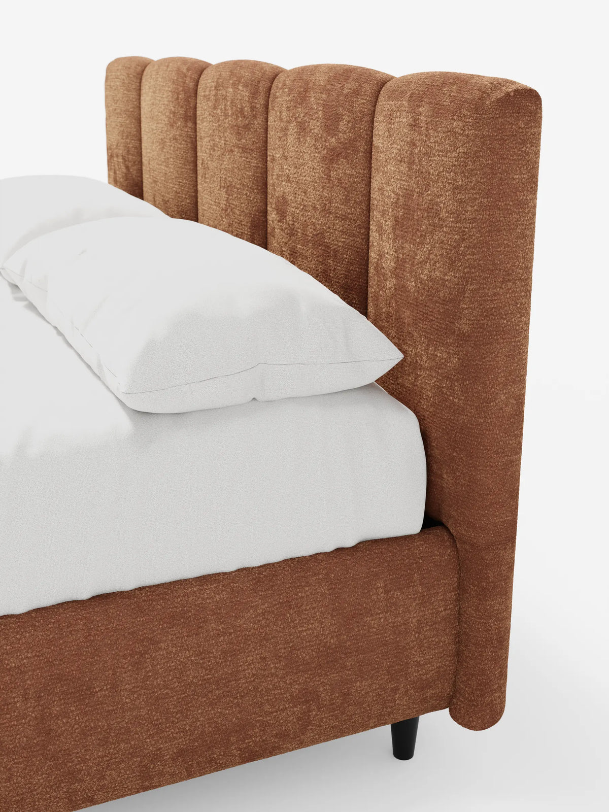 Un primo piano di un letto imbottito ARKAM con contenitore e testiera a lavorazione verticale, caratterizzato da una struttura color ruggine con scanalature verticali, biancheria da letto di un bianco brillante e gambe cilindriche scure.