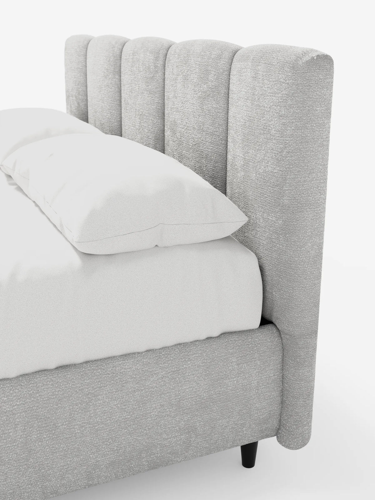 Il letto imbottito ARKAM con contenitore e testiera a canalini verticali è un letto imbottito di colore grigio chiaro, caratterizzato da una testiera con canalini verticali, tessuto testurizzato, biancheria da letto di un bianco brillante e piccoli piedini cilindrici scuri.