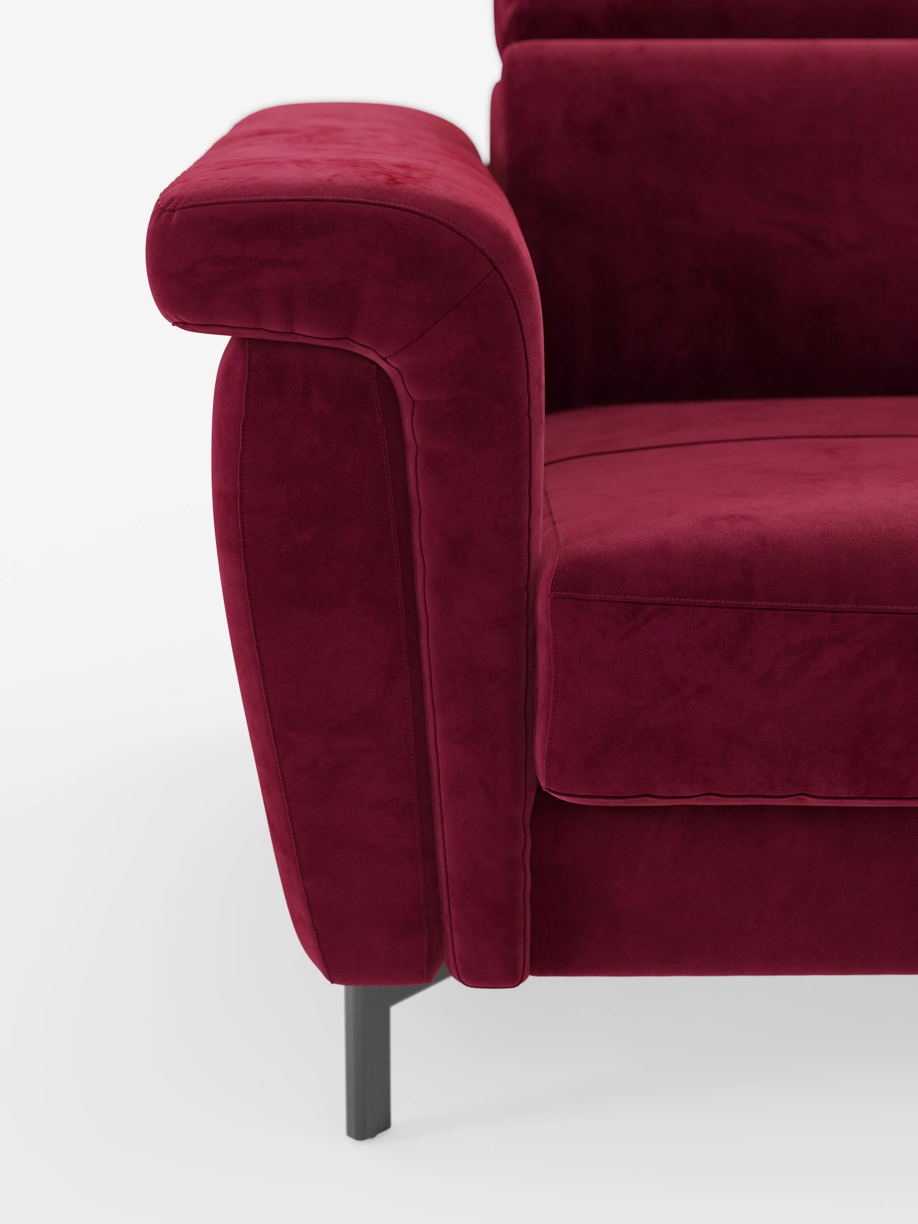 Primo piano del bracciolo sinistro e della seduta del divano letto di design Capri di Divani.Store, rivestito in un lussuoso e ricco tessuto color bordeaux effetto velluto smacchiabile T30 con cuciture a vista. Il divano poggia su gambe alte e slanciate in metallo nero su uno sfondo bianco a tinta unita, mettendo in risalto la raffinata manifattura italiana e caratterizzandosi per il design elegante con poggiatesta reclinabili.