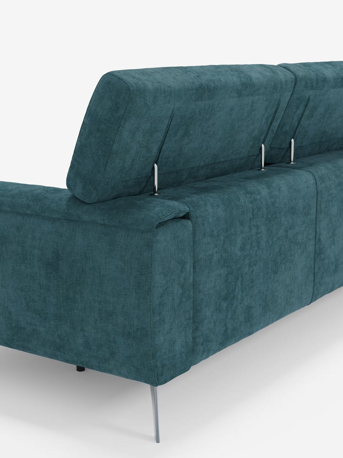 Un primo piano del divano Caravaggio a 4 posti con tre sedute scorrevoli di Divani.Store, color verde acqua, dotato di poggiatesta regolabili e sottili gambe in metallo color argento. Il tessuto T31, vellutato e resistente alle macchie, e lo sfondo bianco a tinta unita mettono in risalto il design audace e moderno di questo divano.