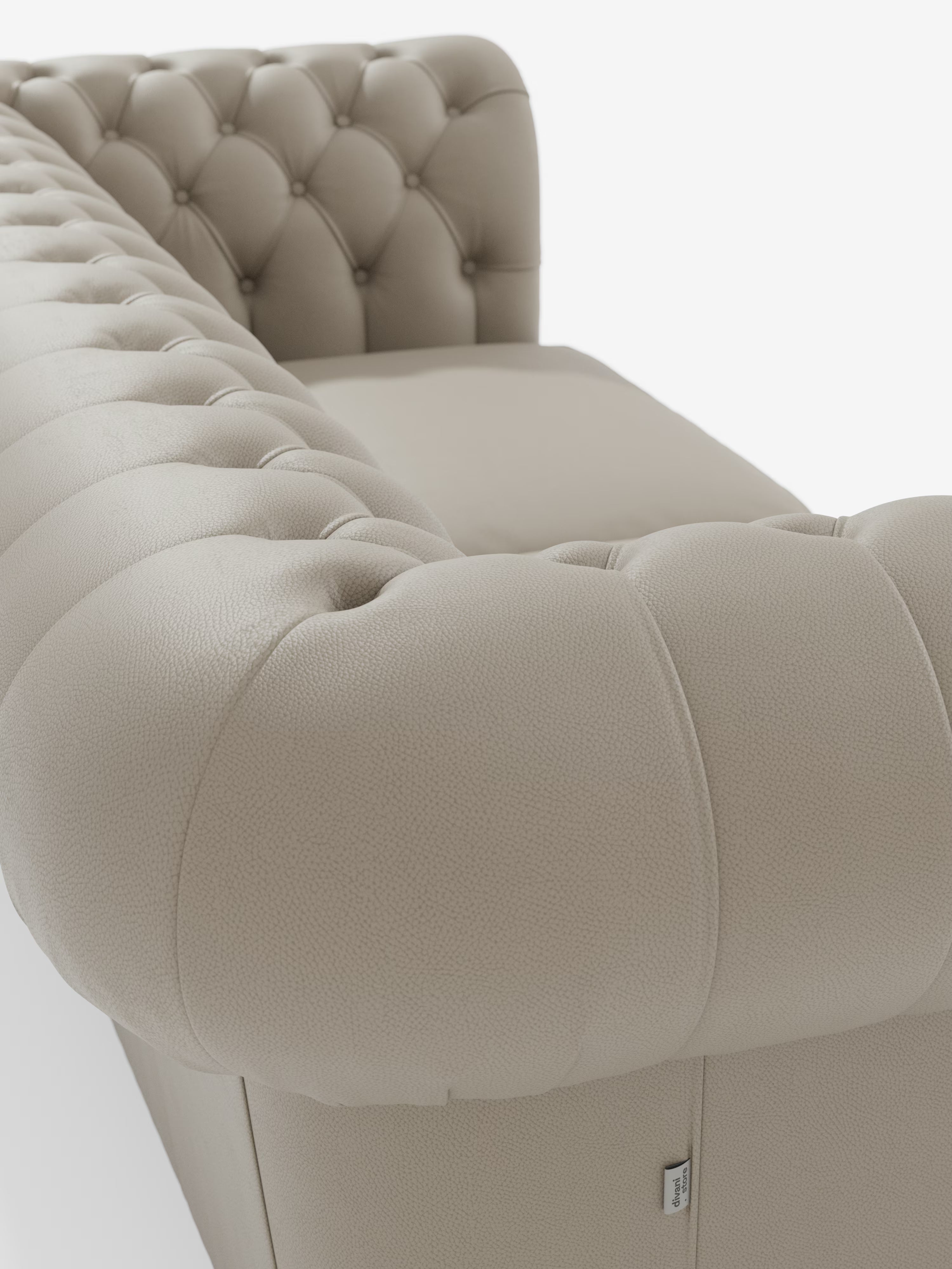 Primo piano del Chester – Divano Chesterfield in vera pelle spessorata a 2 e 3 posti di Divani.Store, che mette in risalto i dettagli a bottoni sullo schienale e sui braccioli. Scattata da un'angolazione particolare, l'immagine mette in risalto il rivestimento morbido e materico e i robusti braccioli su uno sfondo bianco a tinta unita, valorizzando questo elegante divano Made in Italy e attirando l'attenzione sulle sue caratteristiche di design senza tempo.