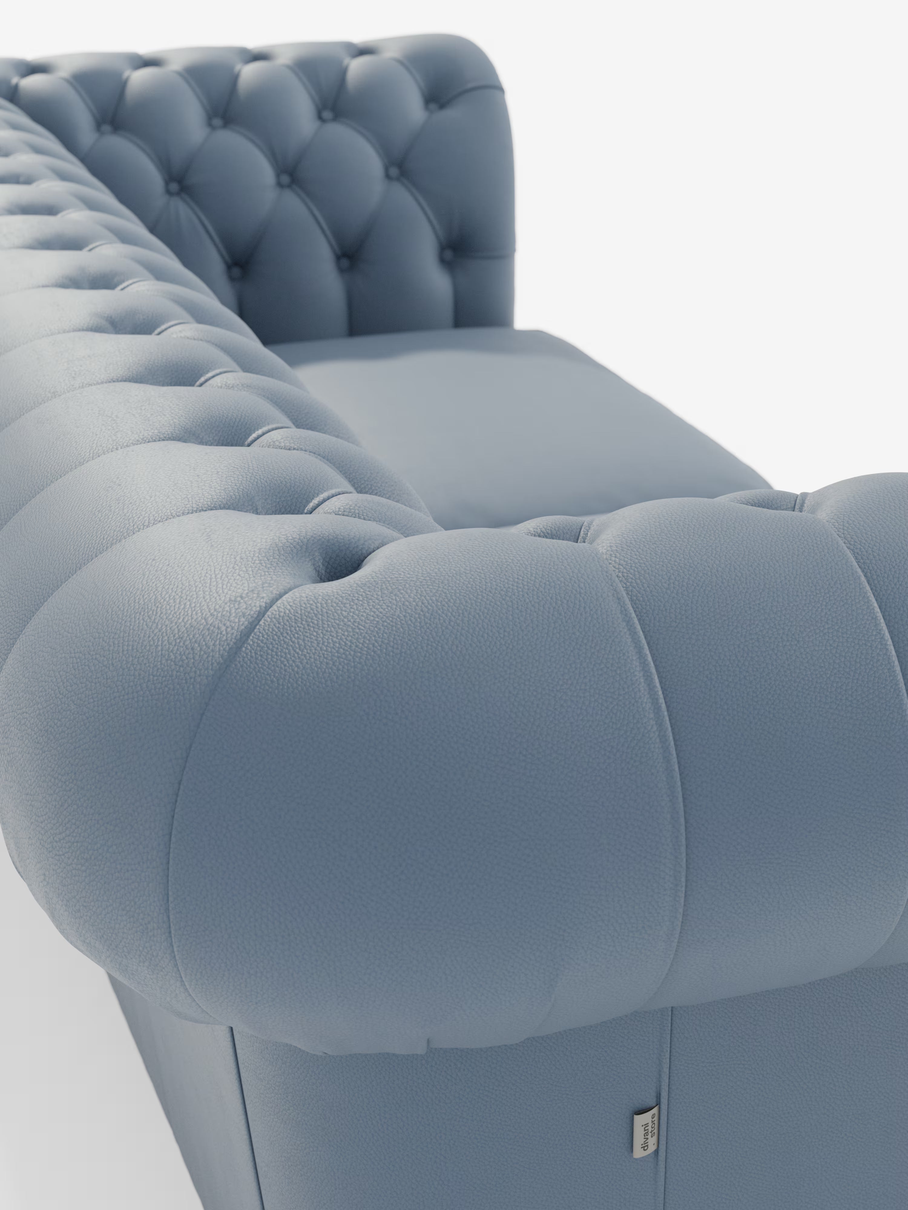 Un primo piano del Chester – Divano Chesterfield in vera pelle spessorata a 2 e 3 posti di Divani.Store mette in risalto il rivestimento con profondi bottoni capitonné, i braccioli elegantemente arrotondati e la pelle blu dalla ricca trama. Questo divano artigianale italiano è un esempio di eccezionale maestria artigianale e stile lussuoso, presentato su uno sfondo bianco e pulito.