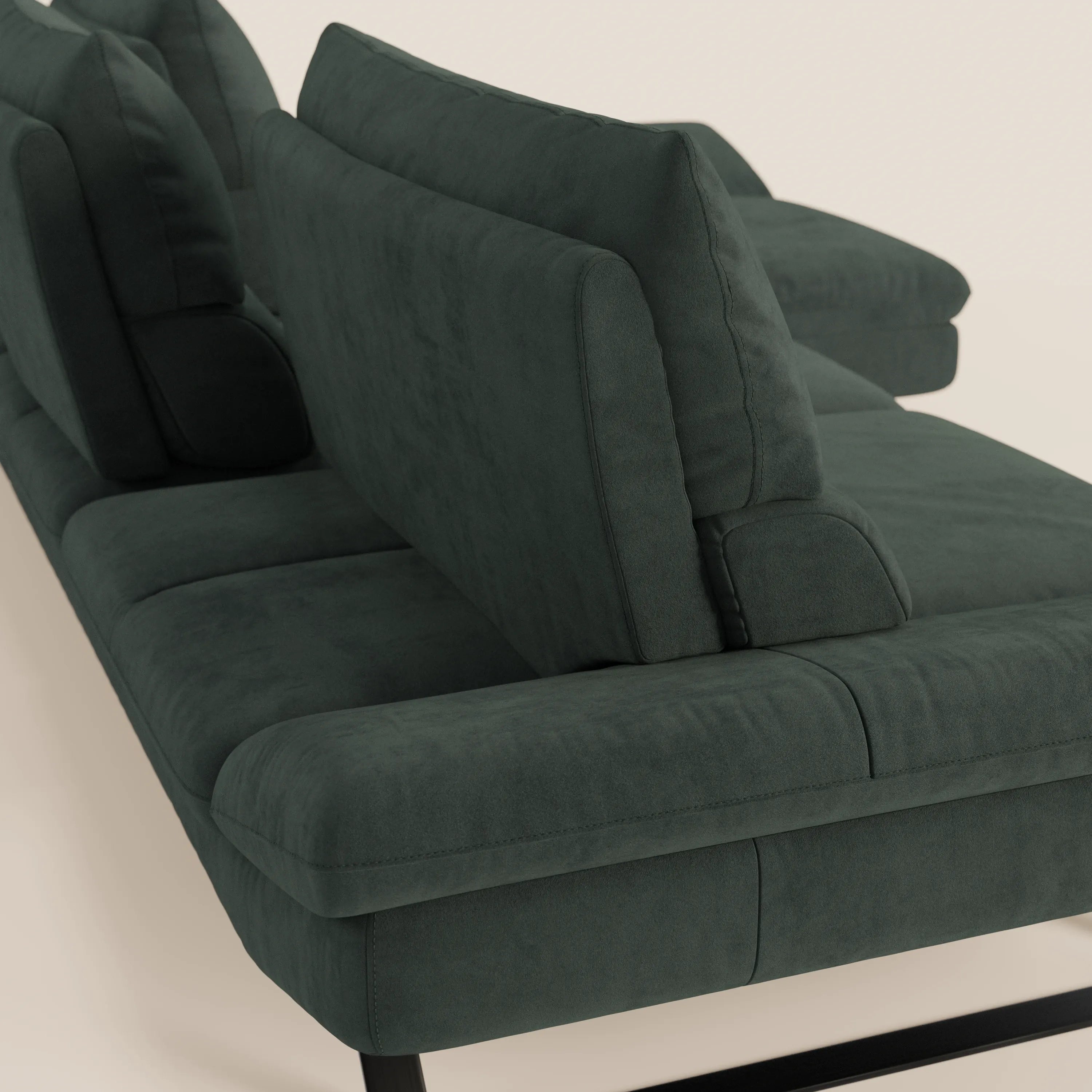 Un primo piano di Eclipse Divano angolare con penisola e schienali traslanti in microfibra tecnica smacchiabile T11 di Divani.Store, che mostra i cuscini in peluche verde scuro, la base bassa in metallo nero e gli schienali mobili da un'angolazione laterale.