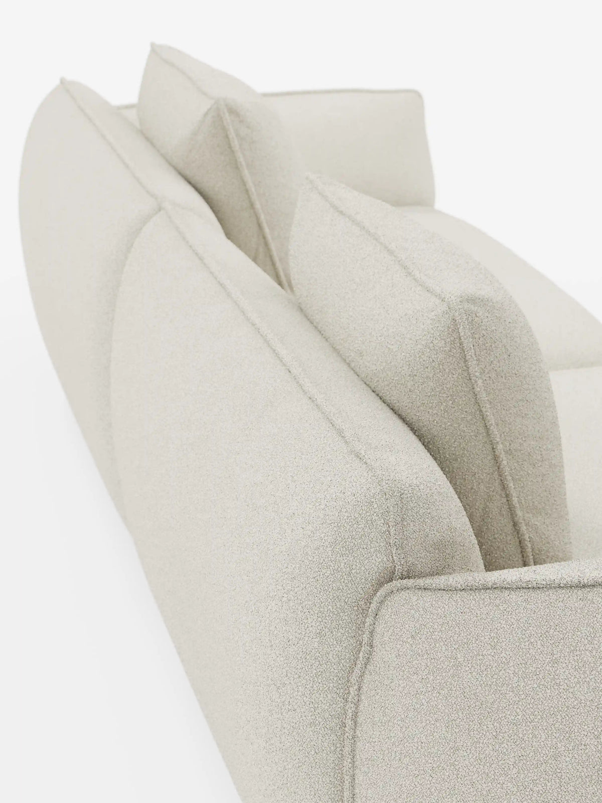 Un primo piano della parte posteriore e superiore del moderno divano Nimbus a 3 posti, modulare e componibile, da 250 cm, di Divani.Modello disponibile in tessuto beige chiaro sfoderabile con finitura effetto cotone antimacchia (t33), caratterizzato da due grandi cuscini dello schienale e da linee pulite e arrotondate, su sfondo bianco.