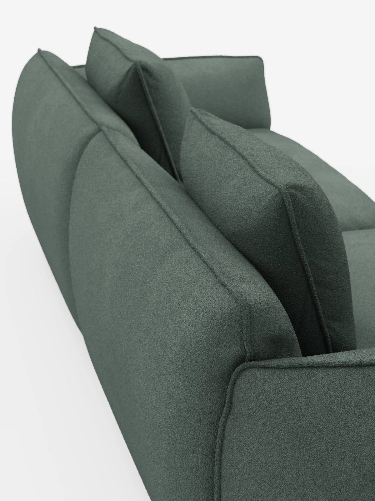 Una vista ravvicinata e obliqua del divano Nimbus a 3 posti, modulare e componibile da 250 cm di Divani.Store, presentato con un rivestimento moderno in verde scuro, smacchiabile, effetto cotone T33. Il divano modulare è dotato di due cuscini dello schienale e due cuscini decorativi, tutti caratterizzati da un aspetto morbido e testurizzato. Il suo design mette in risalto i bordi puliti e arrotondati ed è presentato su uno sfondo bianco.
