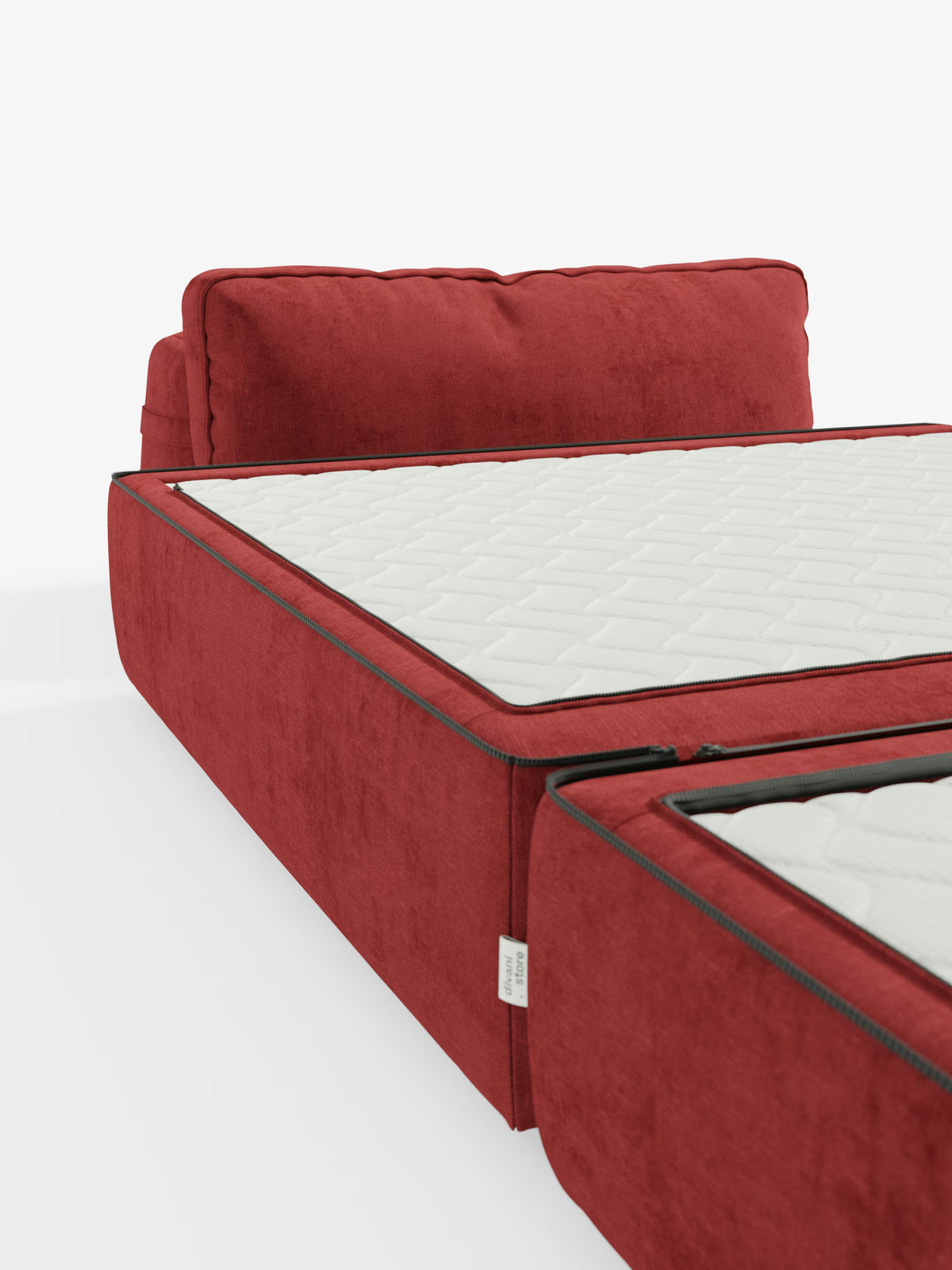 La poltrona letto Rift di Divani.Store, rivestita in rosso con tessuto T31 antimacchia, presenta morbidi cuscini dello schienale e uno schienale mobile regolabile per un comfort personalizzabile. Il materasso in memory foam, alto 24 cm, presenta cuciture a cerniera a vista che delineano le sezioni bianche trapuntate, parzialmente aperte su uno sfondo bianco per un’estetica dal design minimalista.
