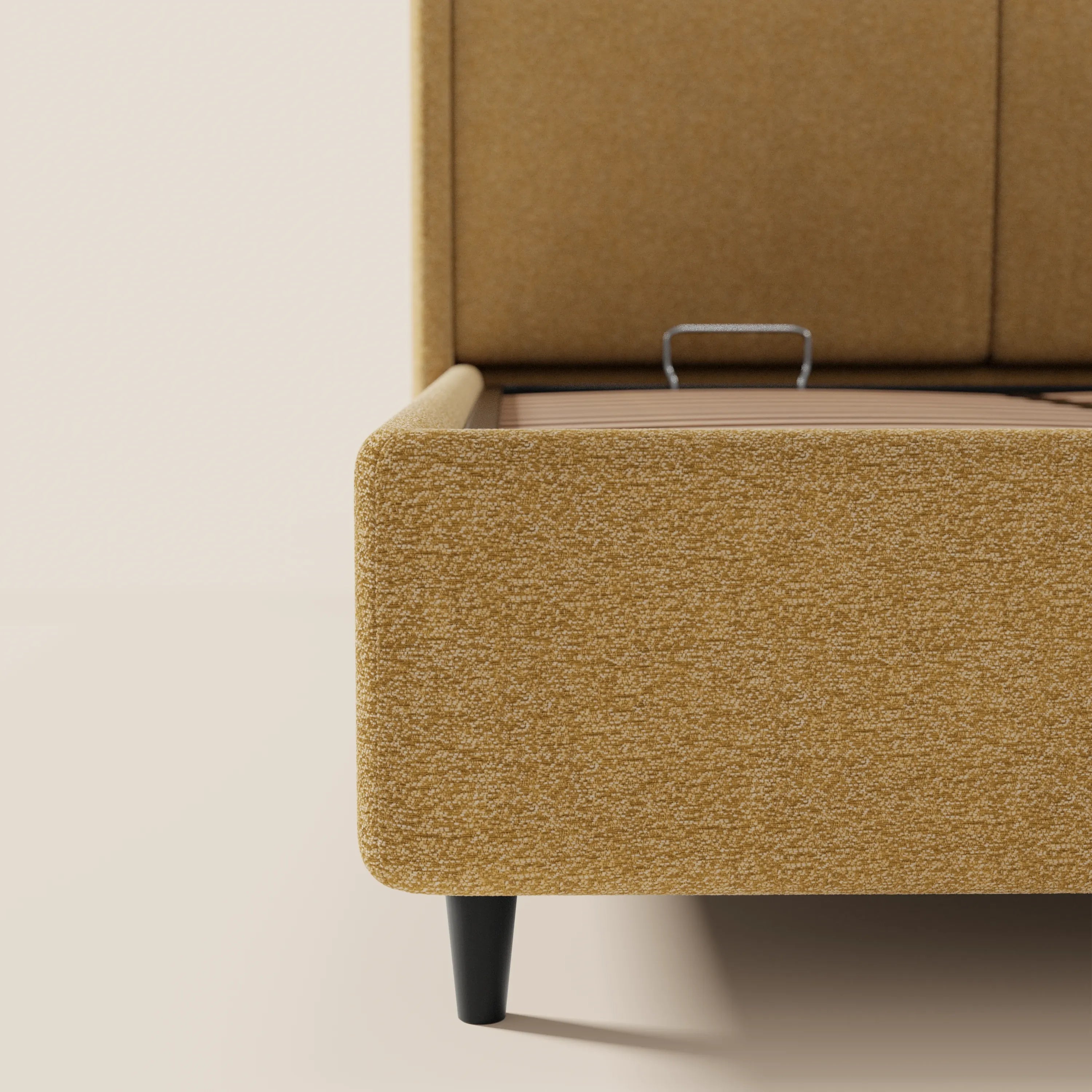 Un primo piano dell’angolo del letto VALKIRIA di Letti.store, un modello di design dotato di vano contenitore e testiera avvolgente in tessuto Oeko-Tex®. Le gambe affusolate nere e una parte della maniglia in metallo ne rivelano il pratico vano contenitore.