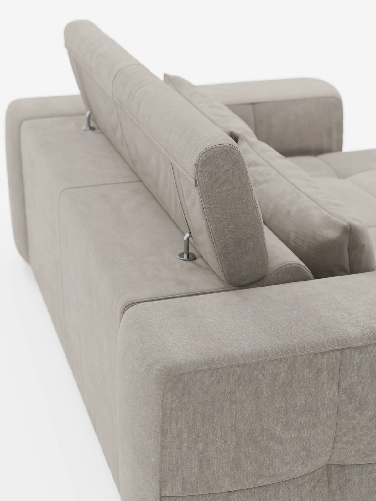 Un divano Monarch color beige chiaro con funzione relax elettrica per l'allungamento delle sedute e poggiatesta reclinabile, rivestito in morbido tessuto smacchiabile T31 di Divani.Il divano è ripreso da dietro e presenta un ampio bracciolo, cuciture a vista e un poggiatesta regolabile sostenuto da staffe metalliche, il tutto su uno sfondo bianco: un elegante esempio di design italiano contemporaneo.