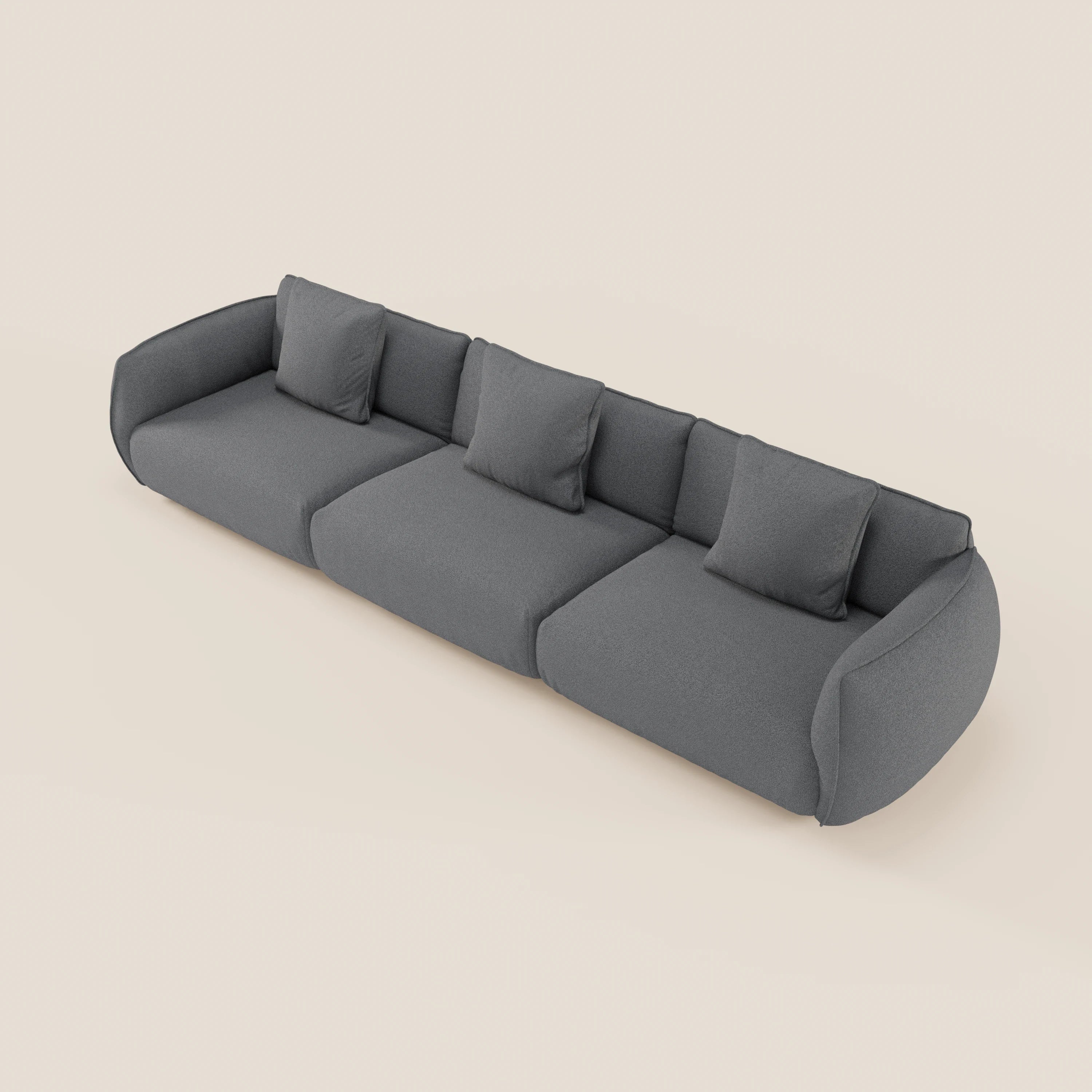 Il divano modulare a 3 sedute Nimbus di Divani.Store, in morbido tessuto T33 smacchiabile effetto cotone, grigio scuro, ha linee minimal e moderne con braccioli arrotondati, schienale basso e quattro cuscini su fondo beige. Completamente sfoderabile.