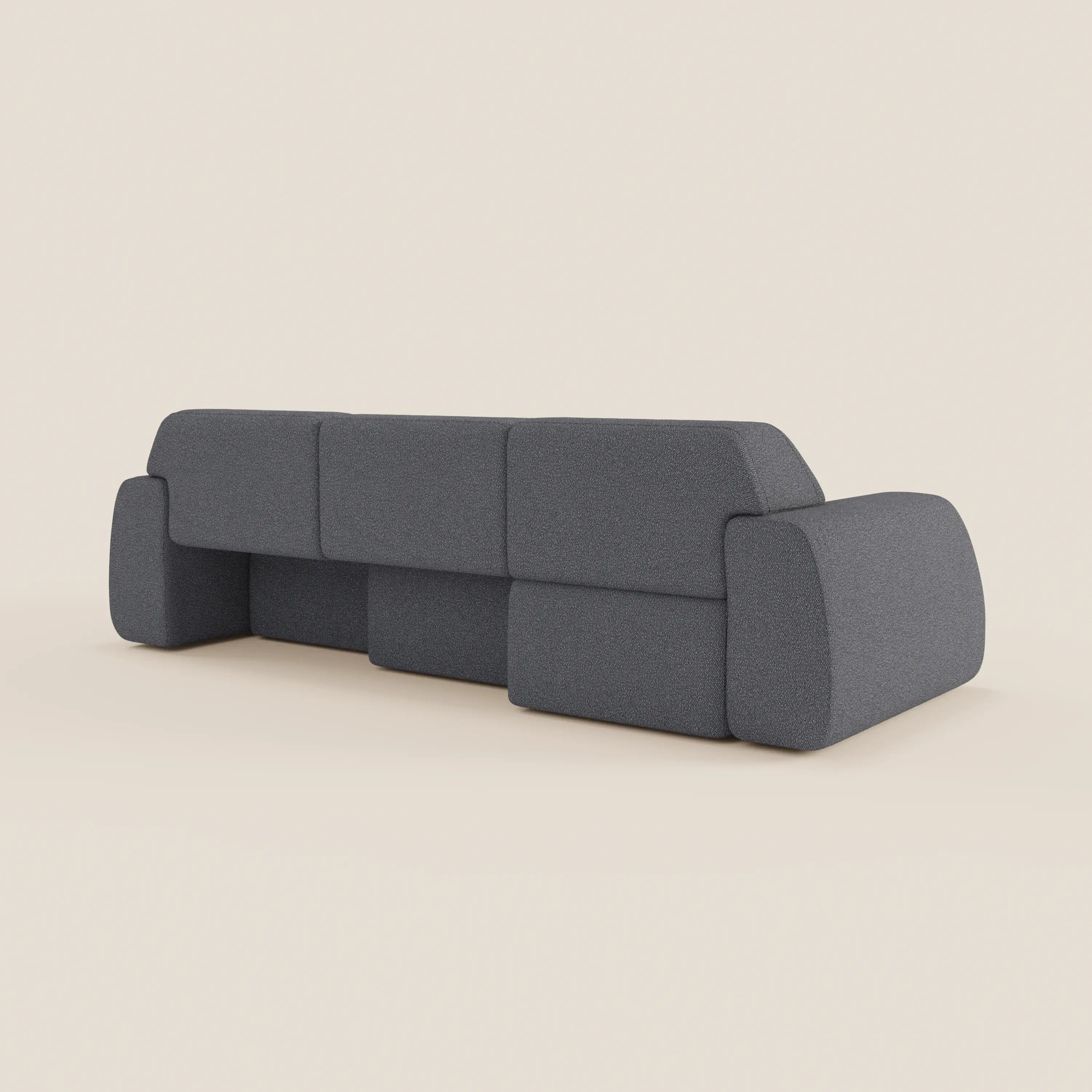 Il divano angolare Orbit con penisola reversibile di Divani.Store in tessuto smacchiabile effetto cotone T33, visto da dietro, mostra tre sedute allungabili e braccioli geometrici su sfondo beige chiaro. Linee pulite e stile moderno.
