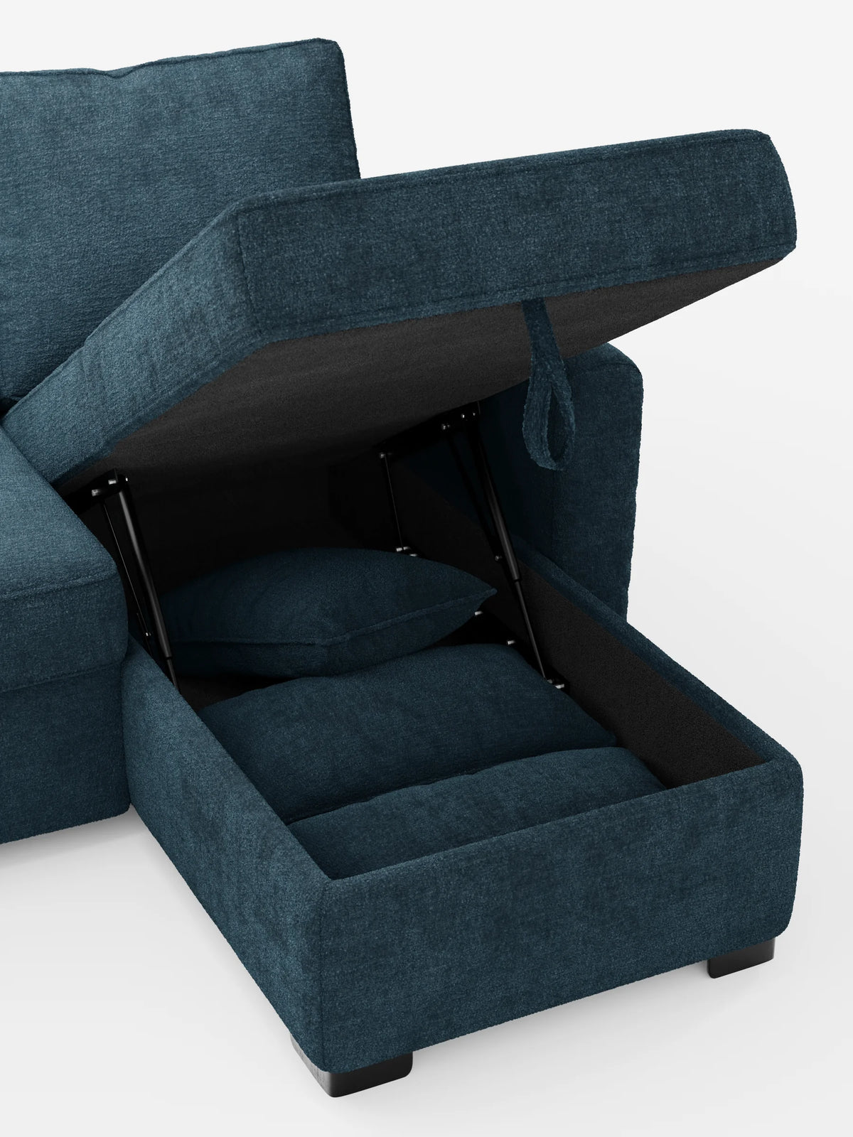 Un divano letto Ottaviano con letto estraibile, penisola reversibile e contenitore in tessuto materico smacchiabile di colore blu, dotato di un vano portaoggetti aperto nella chaise longue con cerniere metalliche interne che rivelano due cuscini coordinati.