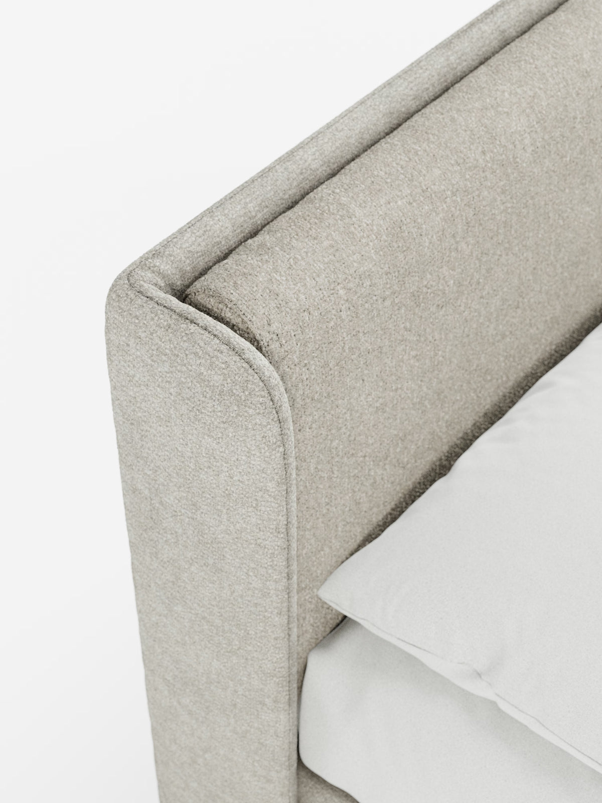Primo piano del letto imbottito bicolore VALKIRIA con contenitore di Letti.store, che mette in risalto il tessuto beige chiaro a trama in rilievo sulla testiera alta e curva avvolgente e sulla struttura. Sono visibili anche un cuscino bianco e parte di un lenzuolo bianco, che esaltano il design pulito e minimalista del letto sullo sfondo bianco.