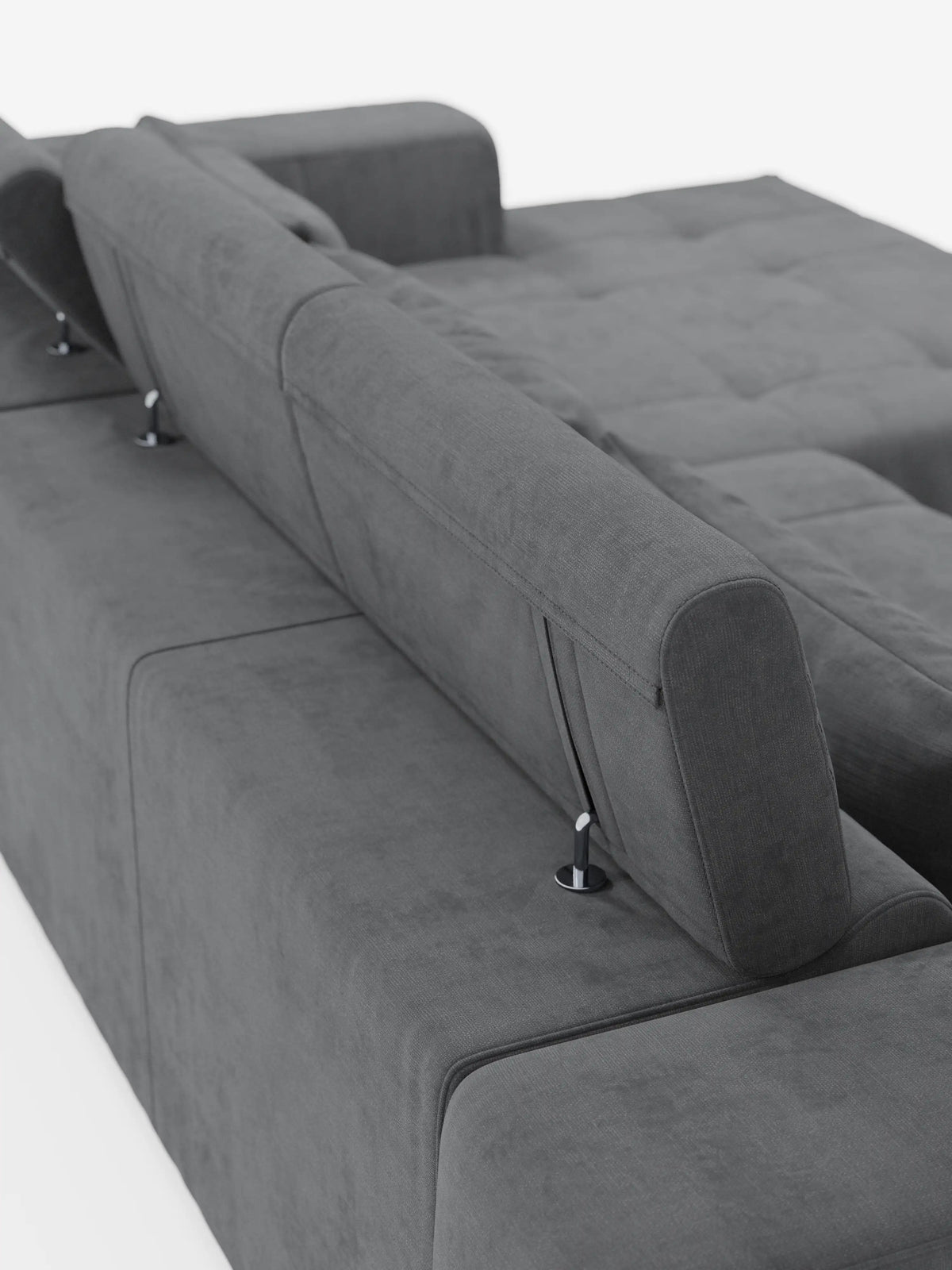 Un primo piano del divano angolare Monarch con penisola e funzione Relax Elettrico per l’allungamento delle sedute, proposto da Divani.Store, ne mette in risalto il moderno design grigio con poggiatesta reclinabili e il morbido rivestimento in tessuto T31 resistente alle macchie. Questo divano componibile presenta imbottitura capitonné ed è esposto su uno sfondo bianco a tinta unita.