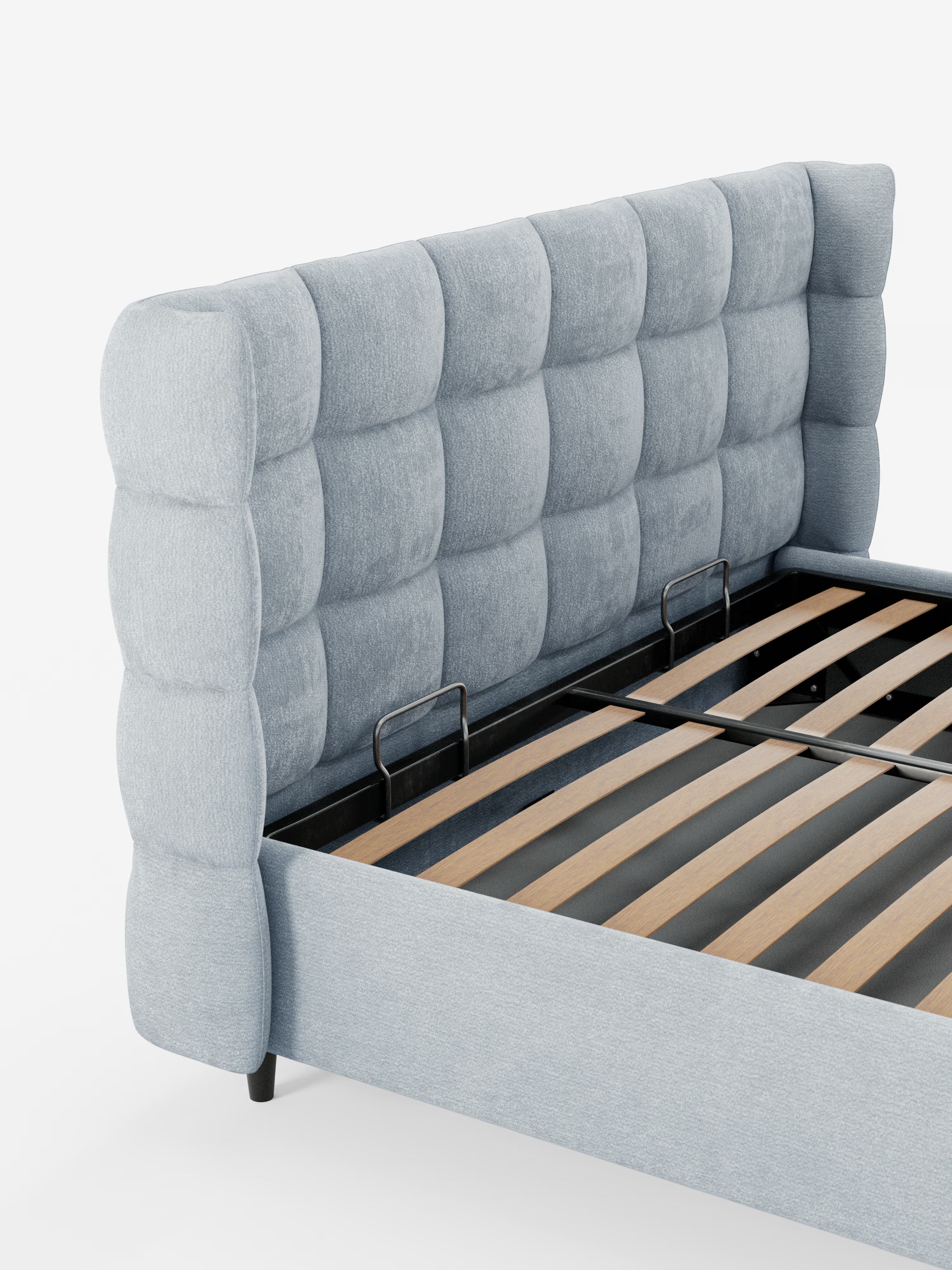 Vi presentiamo il letto imbottito RAGNAR con contenitore e testiera capitonné avvolgente di Letti.store: una struttura letto imbottita in grigio chiaro, realizzata con un elegante tessuto certificato Oeko-Tex®. Questo design raffinato è caratterizzato da una testiera alta e avvolgente con grandi quadrati imbottiti nel classico stile capitonné. Il letto presenta doghe in legno a vista, robusti supporti in metallo e poggia su corte gambe nere, il tutto su uno sfondo bianco a tinta unita.