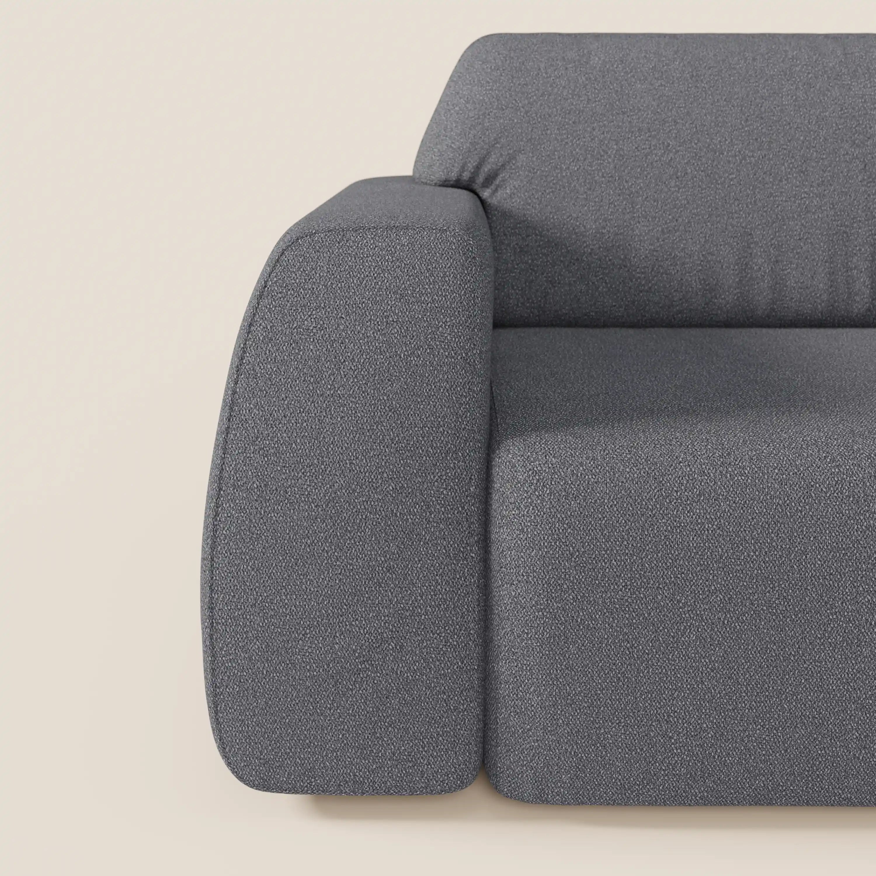 Primo piano del lato sinistro del divano Orbit con 3 sedute scorrevoli e allungabili in tessuto effetto cotone smacchiabile T33 di Divani.Store, che mostra il bracciolo spesso e arrotondato e il tessuto strutturato su uno sfondo beige chiaro.