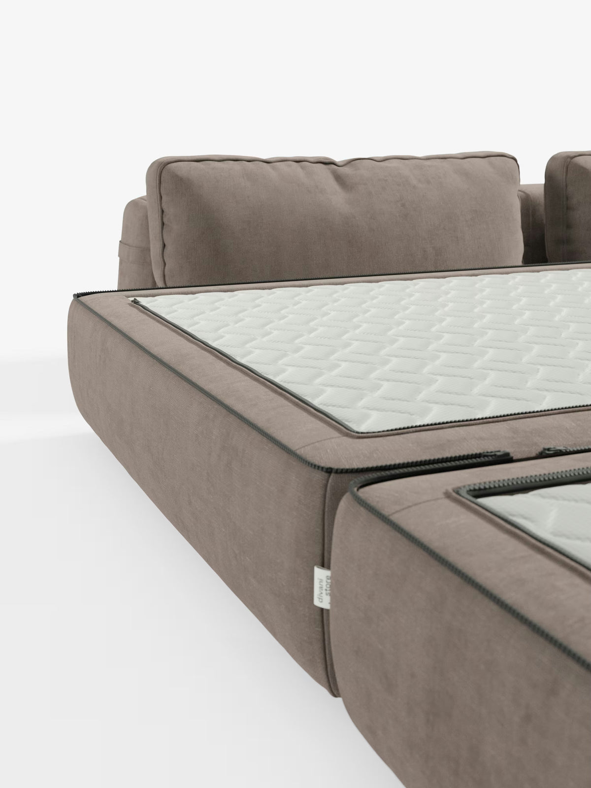 Un primo piano del divano letto matrimoniale Rift a 2 e 3 posti di Divani.Store, un divano letto modulare color taupe, mostra il rivestimento parzialmente aperto che lascia intravedere un materasso bianco con motivo esagonale e un'anima in memory foam alta 24 cm. Gli schienali mobili sono chiaramente visibili, tutti su uno sfondo bianco a tinta unita. Il divano è rivestito in tessuto T31 facile da pulire.