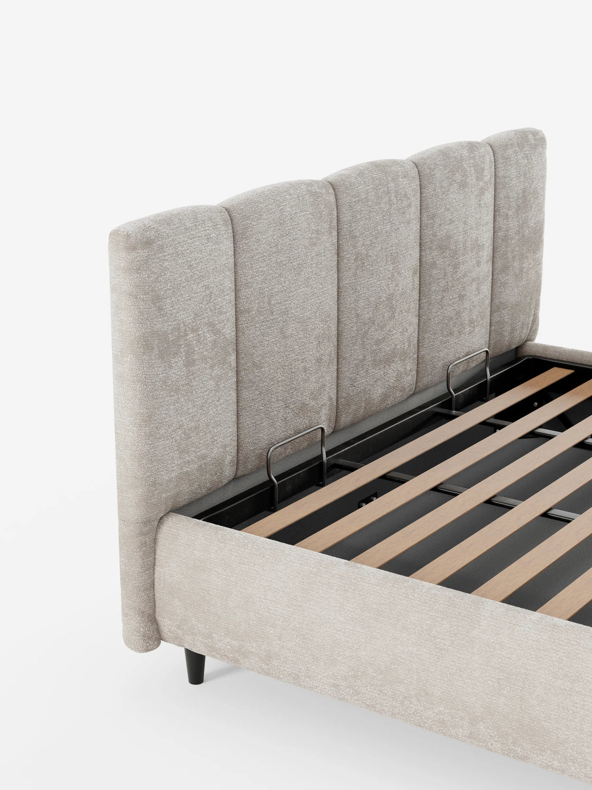 ARKAM, letto imbottito con contenitore e testiera a lavorazione verticale in beige, ripreso da un’angolazione che mette in risalto la rete a doghe in legno e il vano contenitore interno su sfondo bianco.