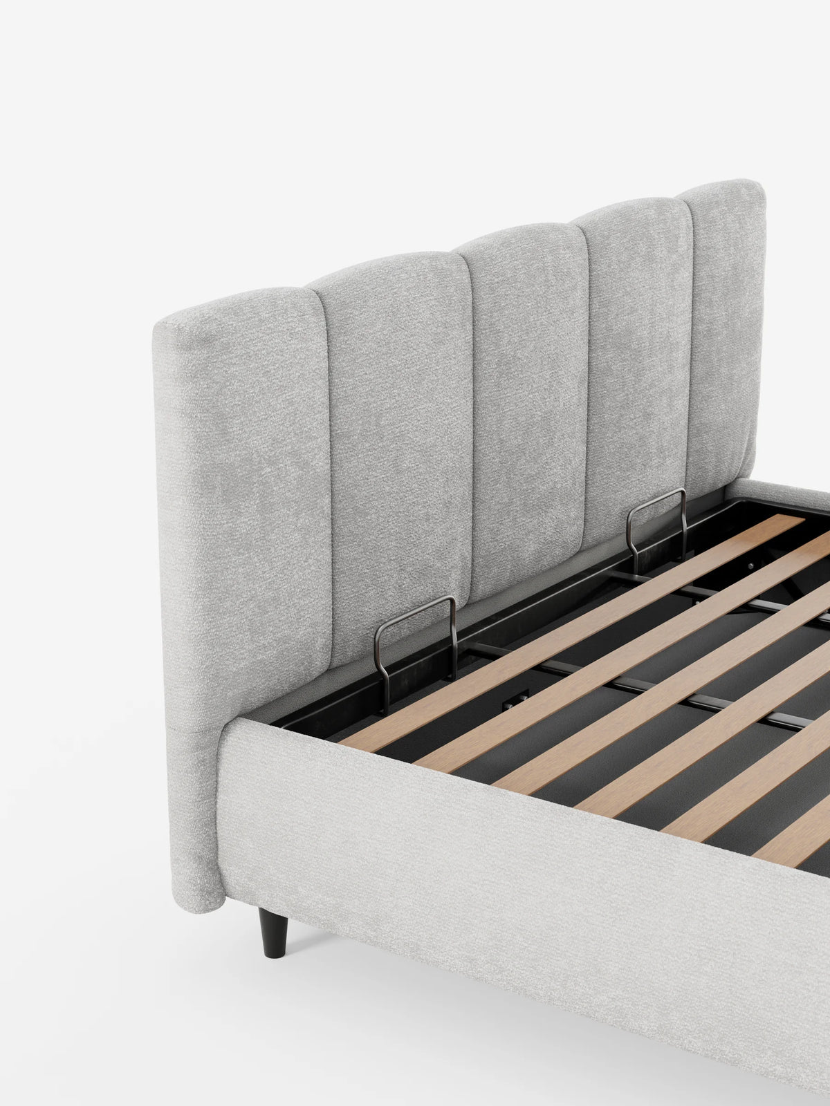 Un letto imbottito ARKAM grigio chiaro con contenitore e testiera a pannellatura verticale; il materasso è stato rimosso per rivelare una base a doghe in legno e staffe di sostegno in metallo su uno sfondo bianco liscio.