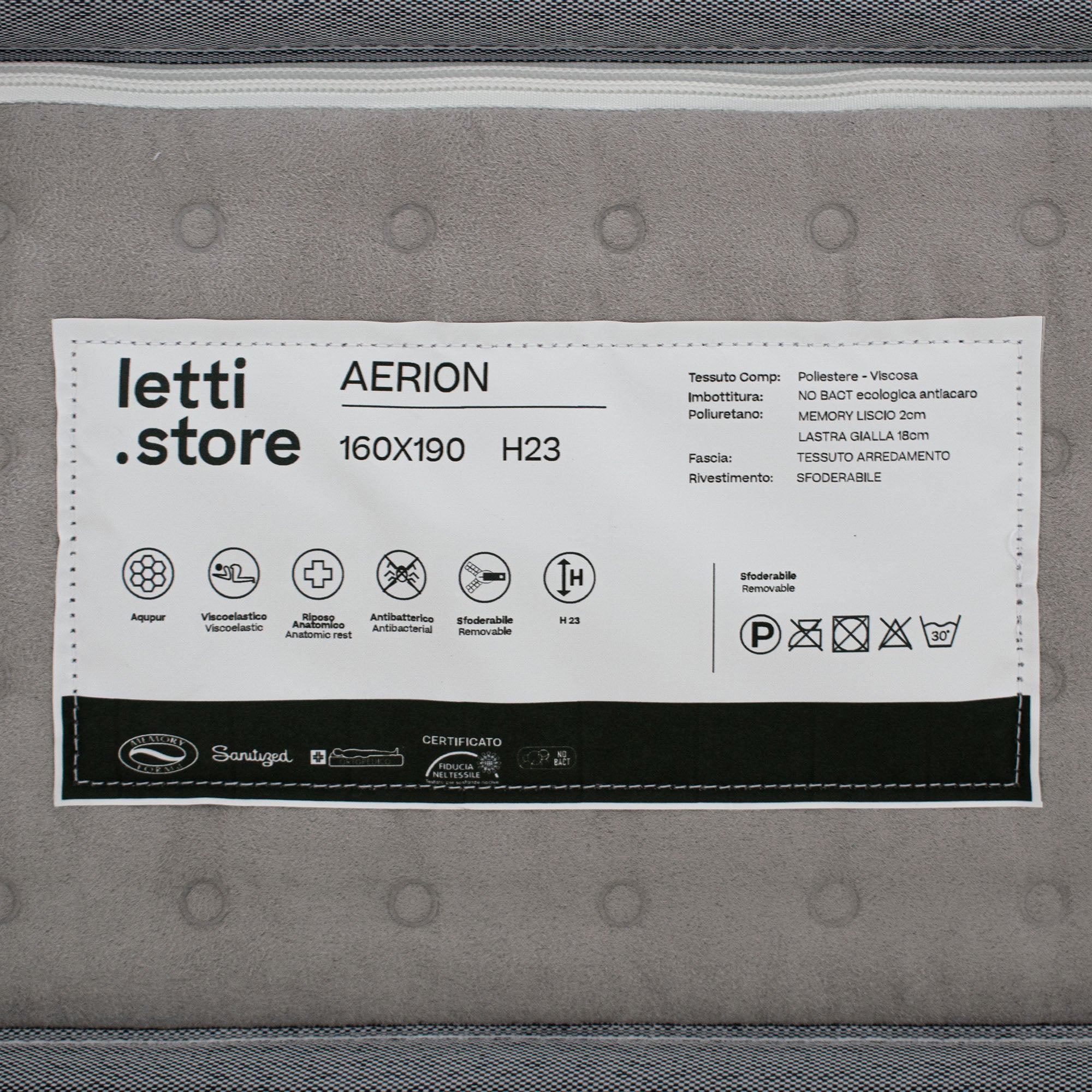Primo piano dell'etichetta di un materasso che riporta il marchio "Divani.Store" e il modello "AERION - Materasso Ortopedico in Memory & Aquapur", dimensioni 160x190 cm H23, con dettagli del tessuto, icone, istruzioni per la cura e informazioni in italiano.