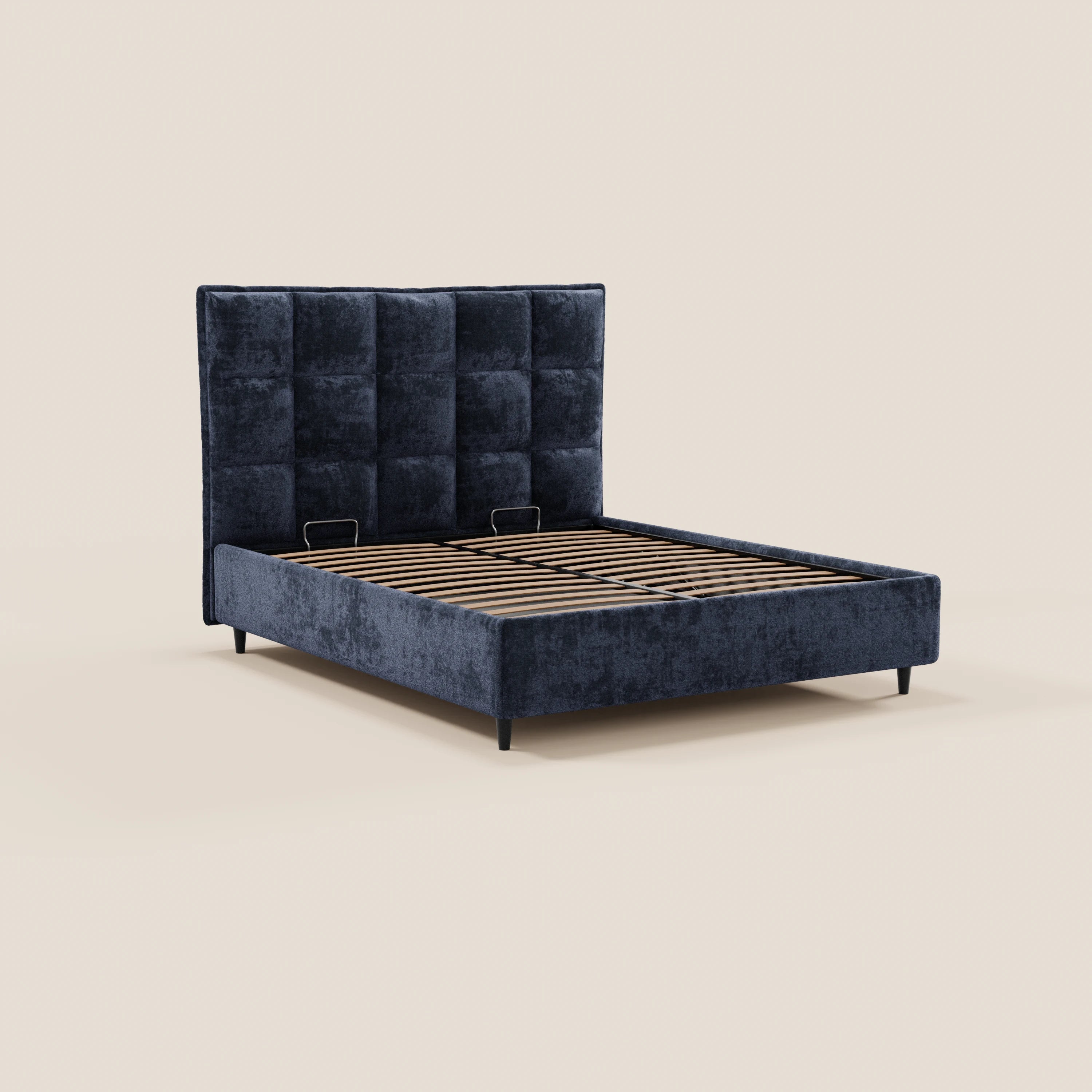 Il letto imbottito AURO di Letti.store presenta una testiera alta in ciniglia blu scuro certificata Oeko-Tex®, con finitura capitonné, fianchi imbottiti in tinta, gambe nere e doghe in legno. Nell’immagine è raffigurato senza materasso né biancheria da letto su uno sfondo beige chiaro.