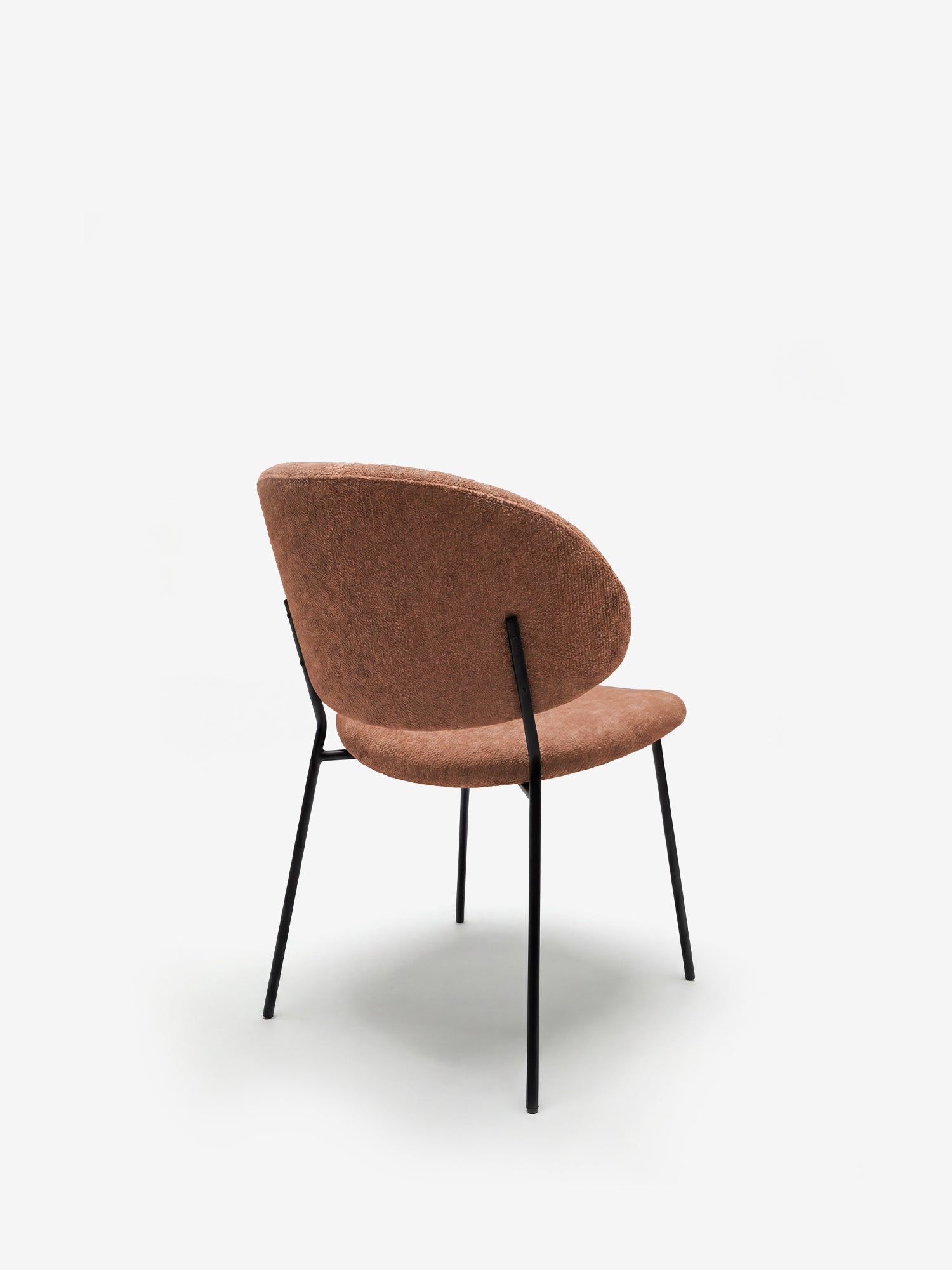 La Bruma di Divani.Store è una sedia dal design minimalista con schienale avvolgente, rivestita in un elegante tessuto goffrato marrone e dotata di sottili gambe in metallo nero. Fotografata su sfondo bianco, è perfetta per gli ambienti moderni.