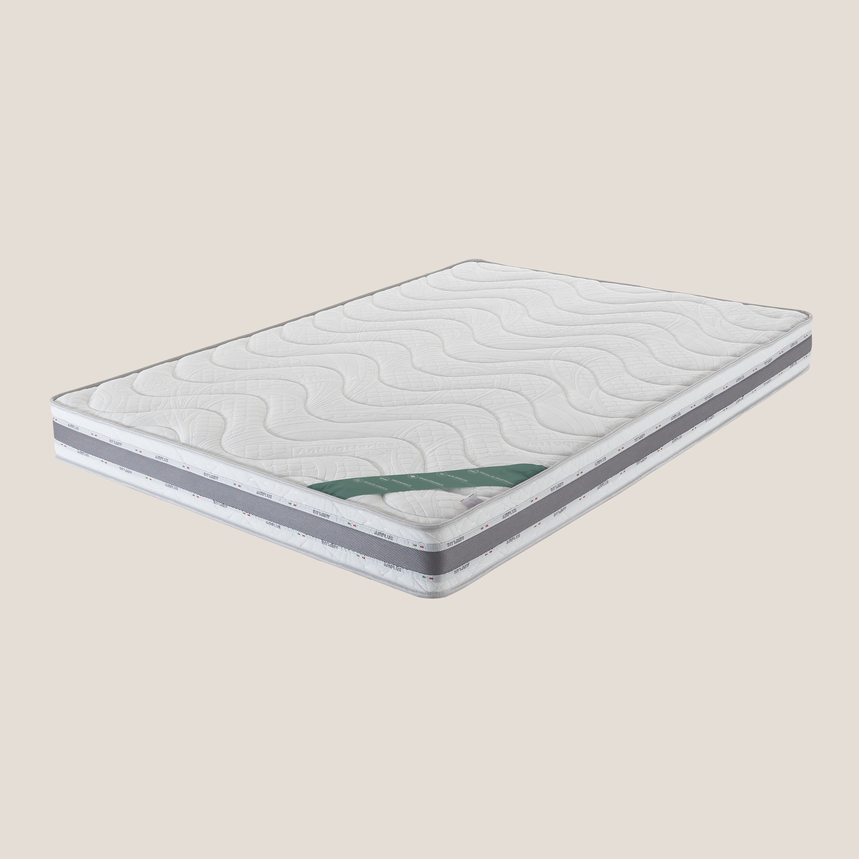 Il materasso in memory foam Comfort+ H18 cm di Divani.Store è caratterizzato da un piano trapuntato bianco con cuciture ondulate, lati grigi con striscia bianca ed etichetta verde. Progettato per i divani letto, è anallergico e traspirante. Mostrato su uno sfondo beige semplice.