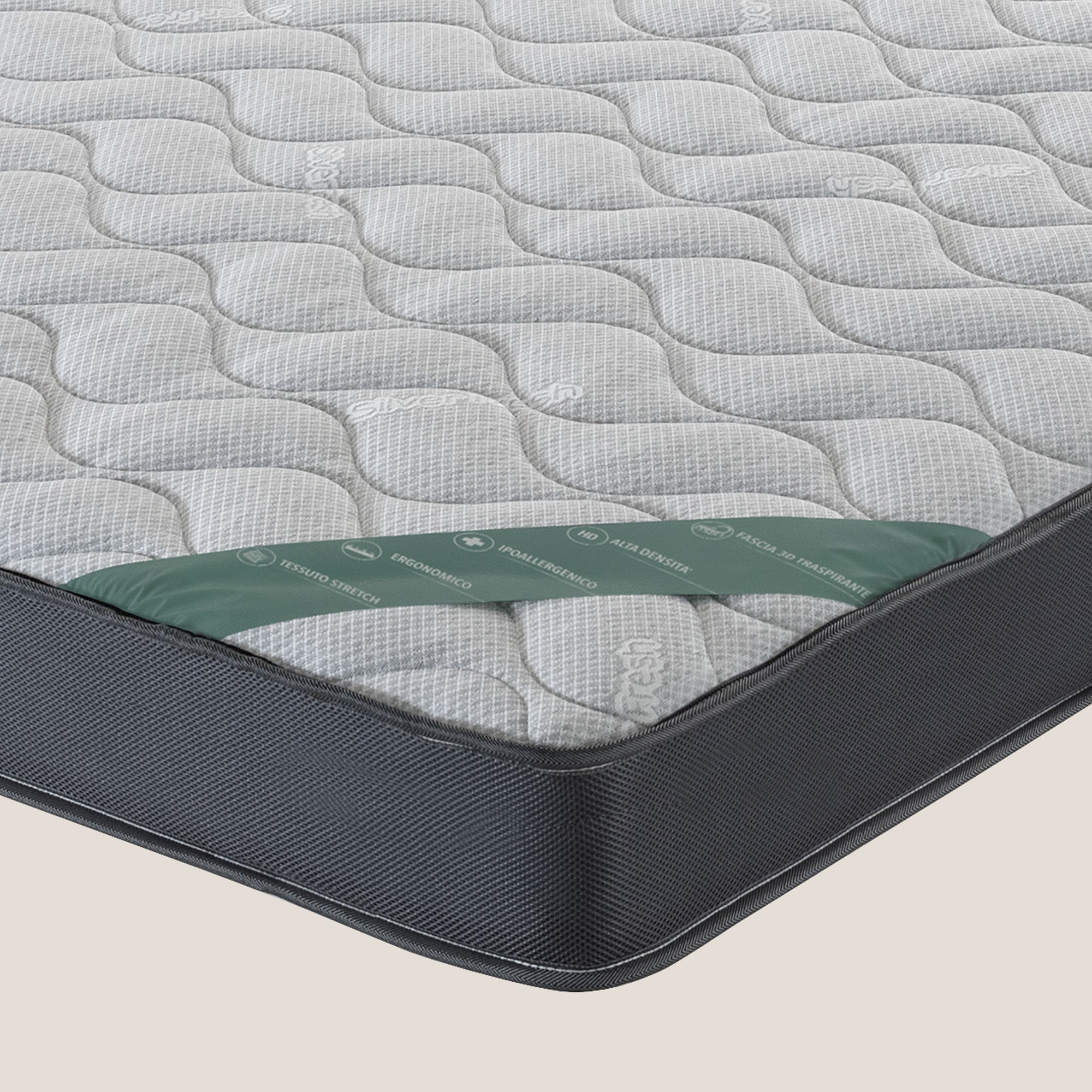 Un primo piano di Comfort+ H16 cm per Doghe di Divani.Store mostra la parte superiore grigio chiaro con cuciture ondulate e piccoli loghi. Il lato tessuto grigio scuro e un'etichetta verde con icone e testo sono visibili sul bordo.