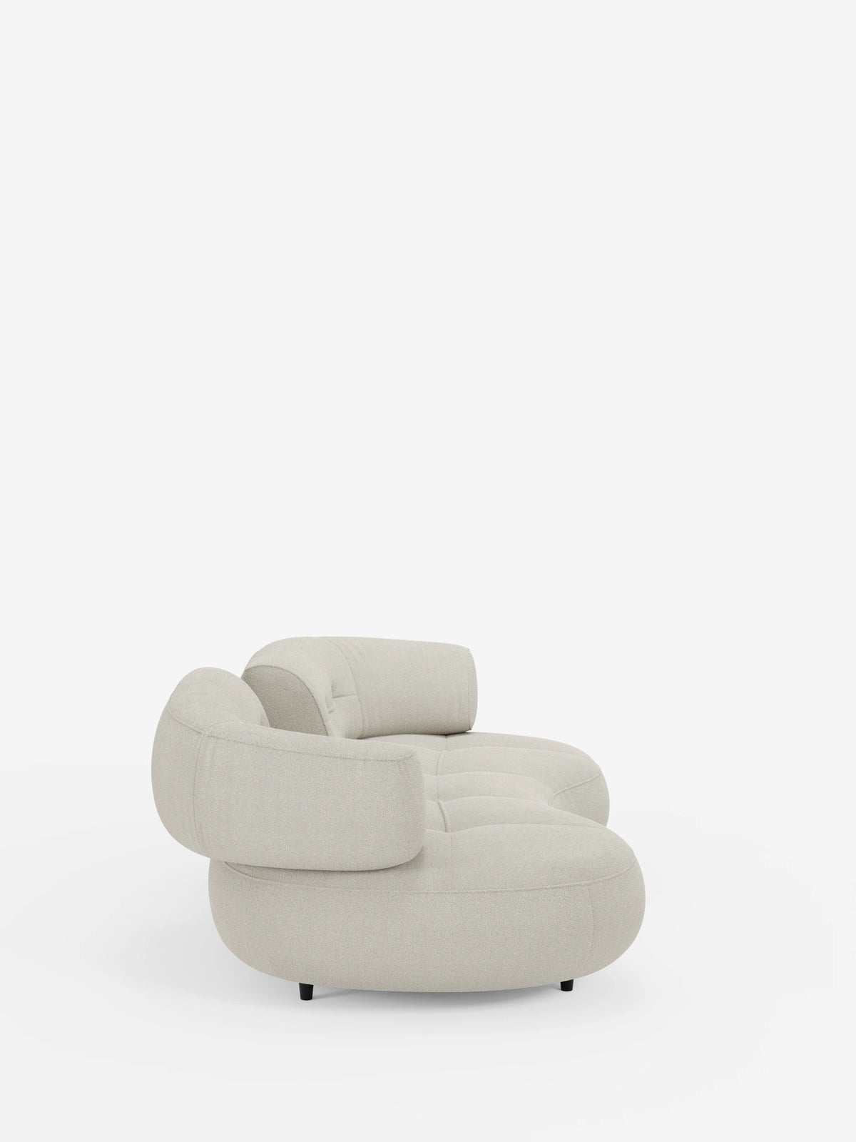 A Croissant: divano curvo a fagiolo a 3 posti con schienali traslanti, rivestito in morbido tessuto effetto cotone smacchiabile T33, caratterizzato da un design curvo, a forma di fagiolo e dal profilo ribassato, in tessuto beige chiaro con cuscini arrotondati e piccoli piedini scuri.