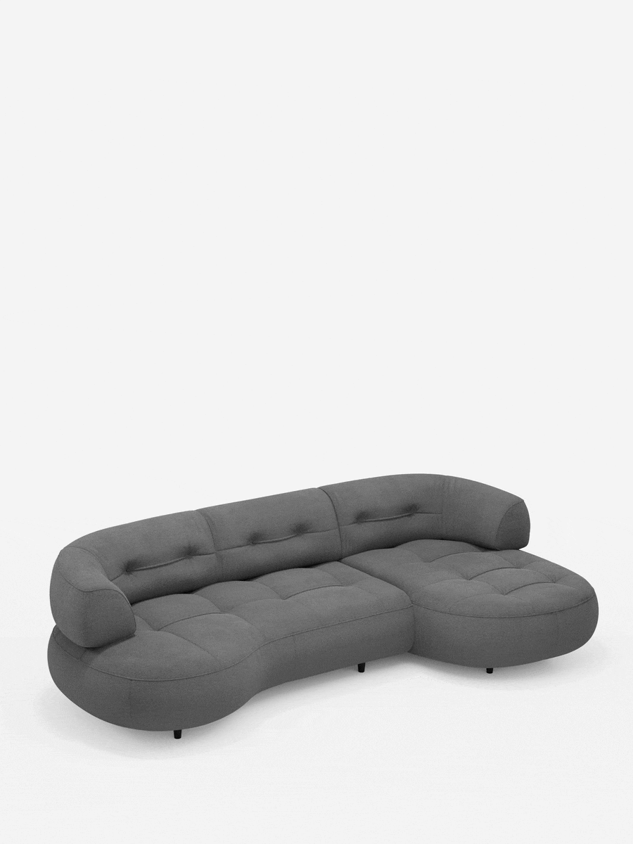 Un divano angolare “Croissant” color grigio antracite, dal design a forma di fagiolo e con schienali scorrevoli in morbido tessuto effetto cotone smacchiabile T33, caratterizzato da bordi arrotondati, seduta e schienale trapuntati e gambe cilindriche basse e scure.